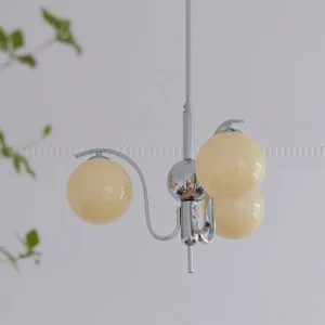 3-head compact glass globe chandelier with beige shades and sleek chrome finish installed in minimalist space