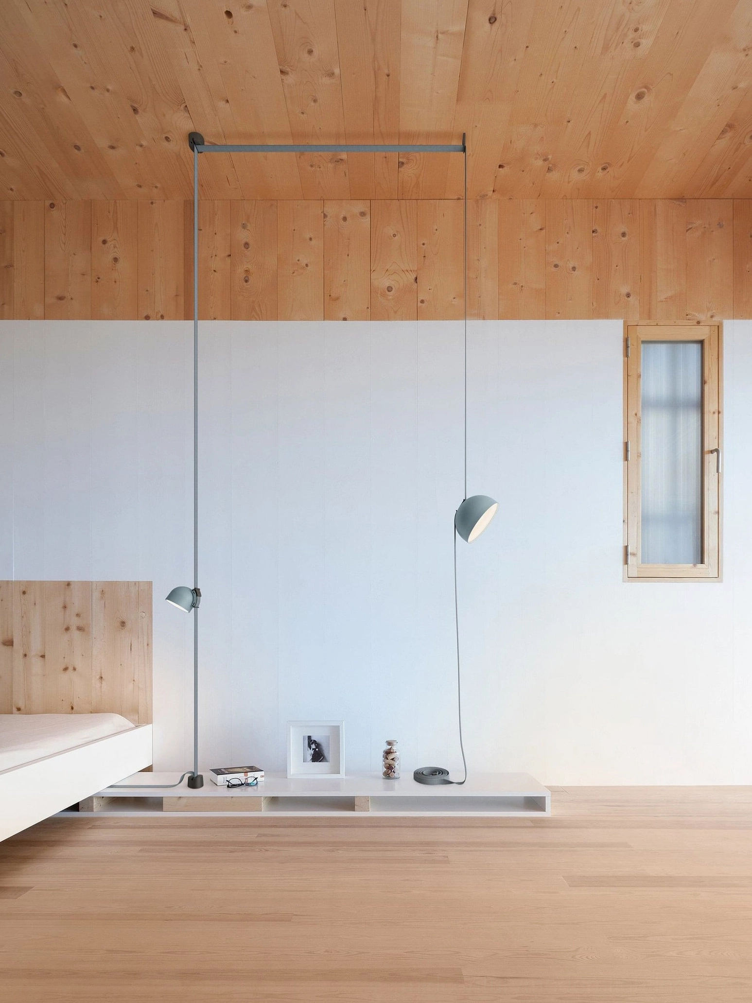 Three-head leather sling pendant lamp installed in modern Nordic bedroom with warm minimalist decor