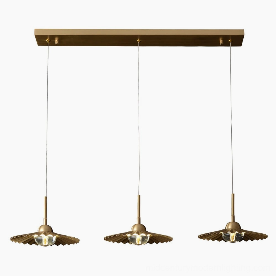 Three-head plié pendant cluster installation showing bold architectural statement above modern dining table