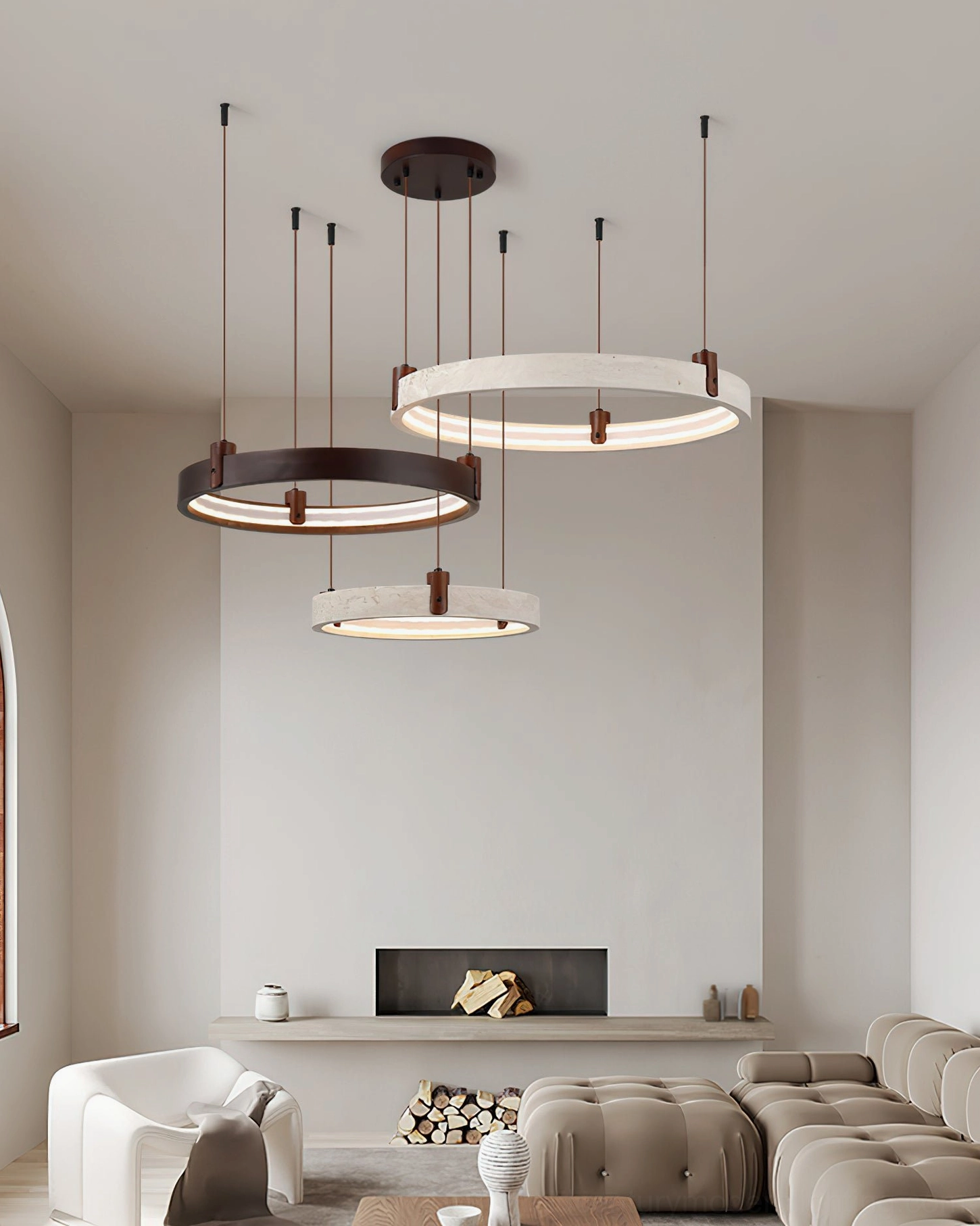 Three-head travertine chandelier suspended over spacious modern sectional living area, showcasing organic minimalist wabi-sabi aesthetic