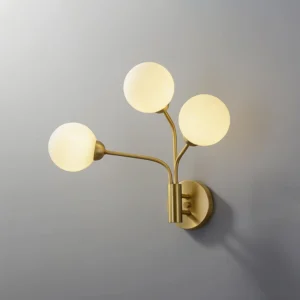 Three-light Chelso wall lamp in brushed brass with opal glass shades studio view
