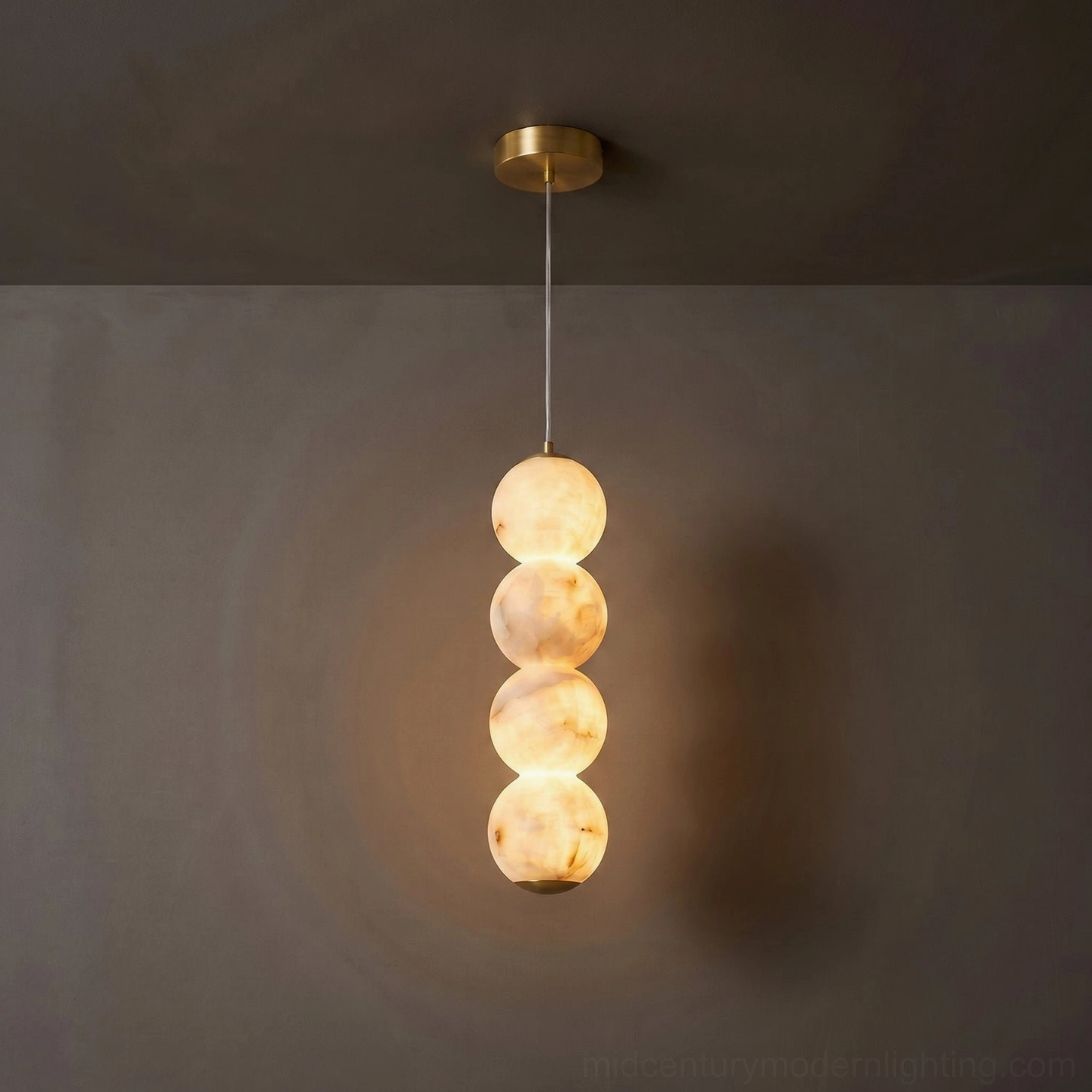 Three-tier stacked alabaster pendant light brass suspension system on neutral background