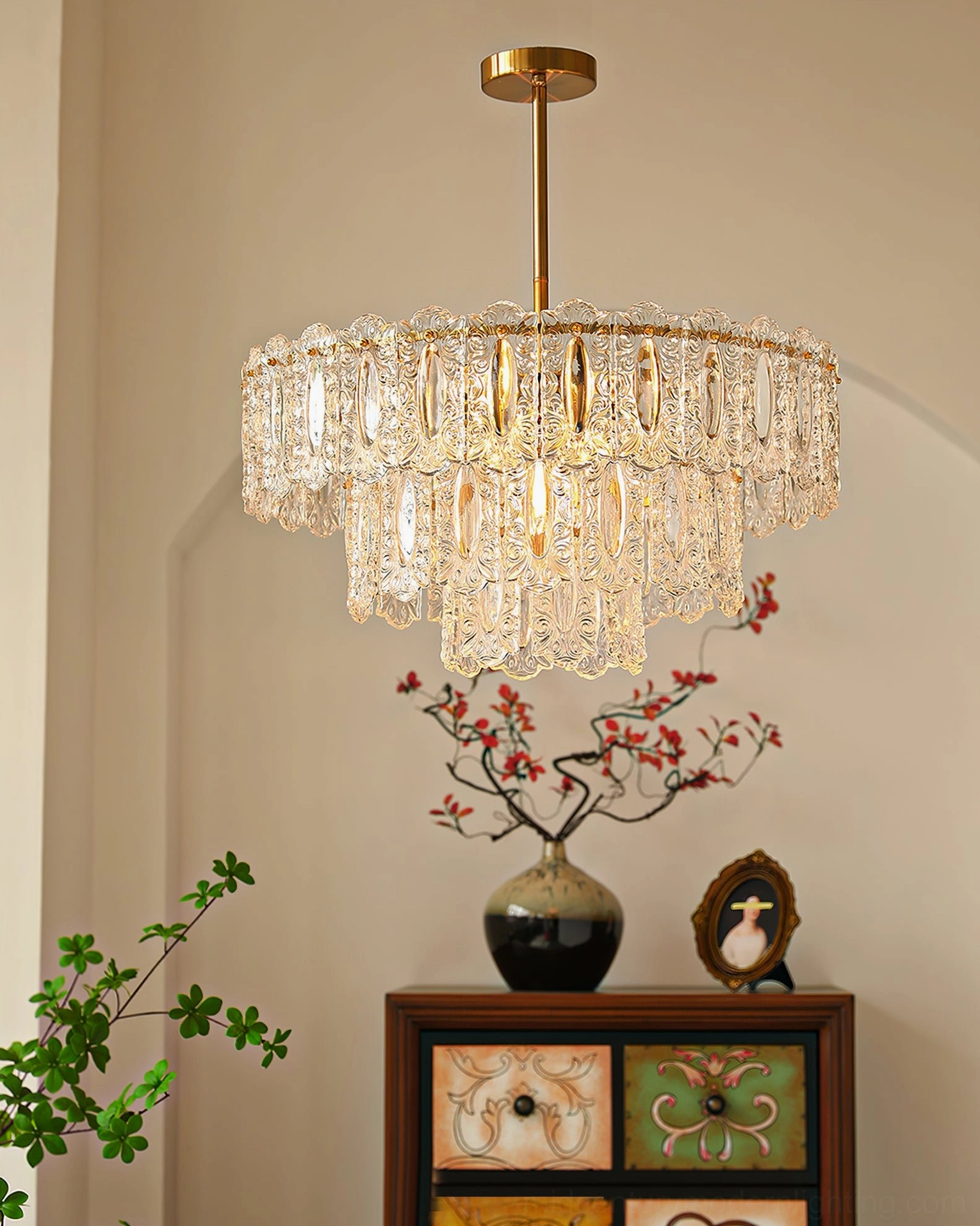 Three-tier brass Vienna crystal chandelier in foyer with vintage warm glowing light and floral decorations