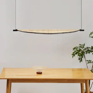 Thula rattan pendant light suspended over wooden dining table in wabi-sabi inspired interior