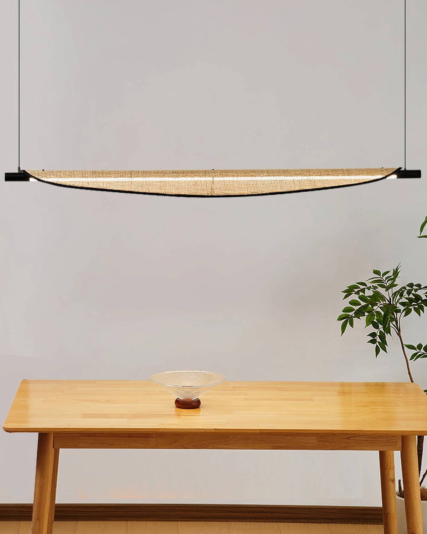 Thula large size linear rattan chandelier creating dramatic lighting feature over expansive wooden dining table