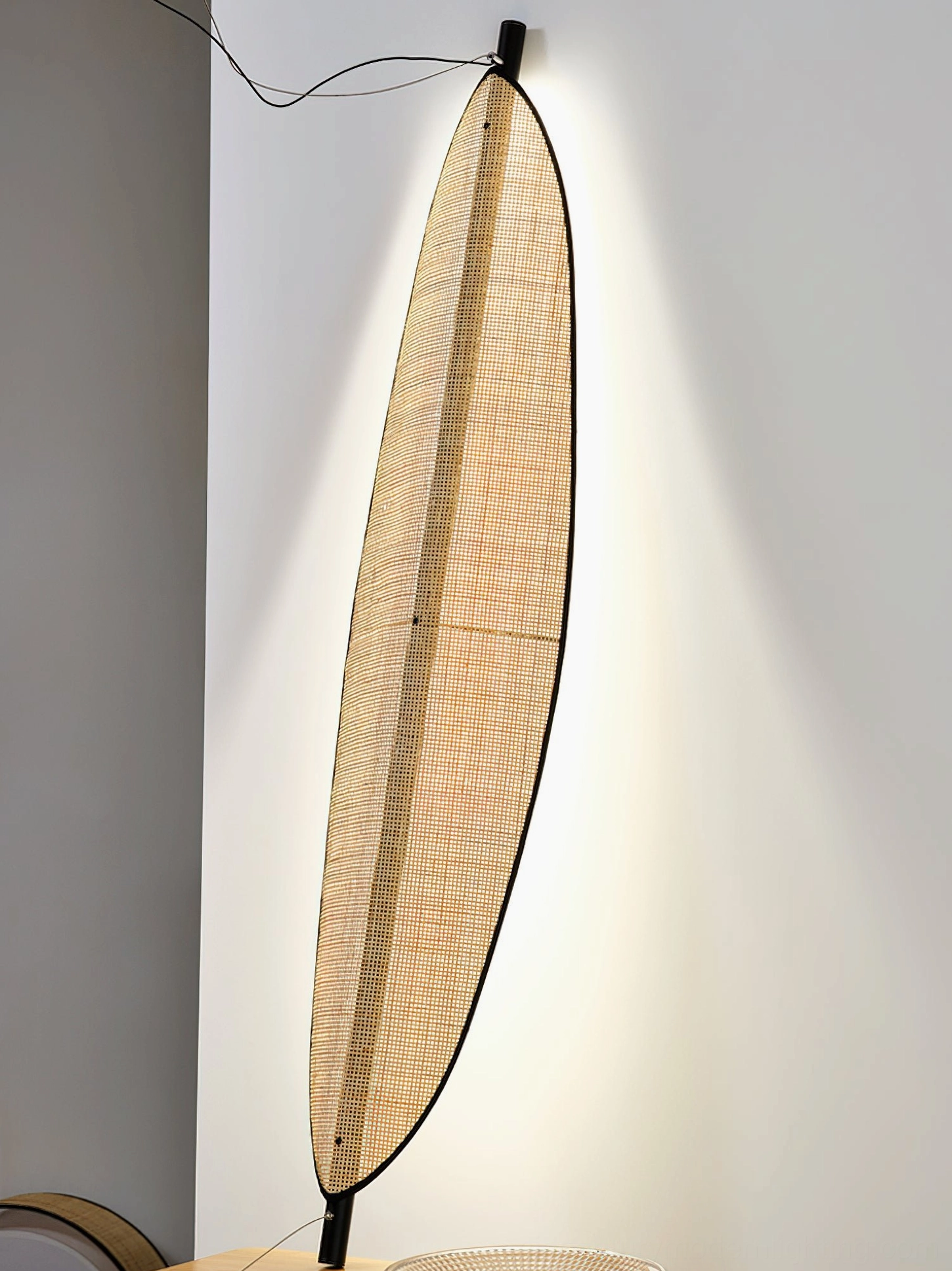 Close-up of Thula handwoven rattan shade with backlit warm ambient light showing texture detail