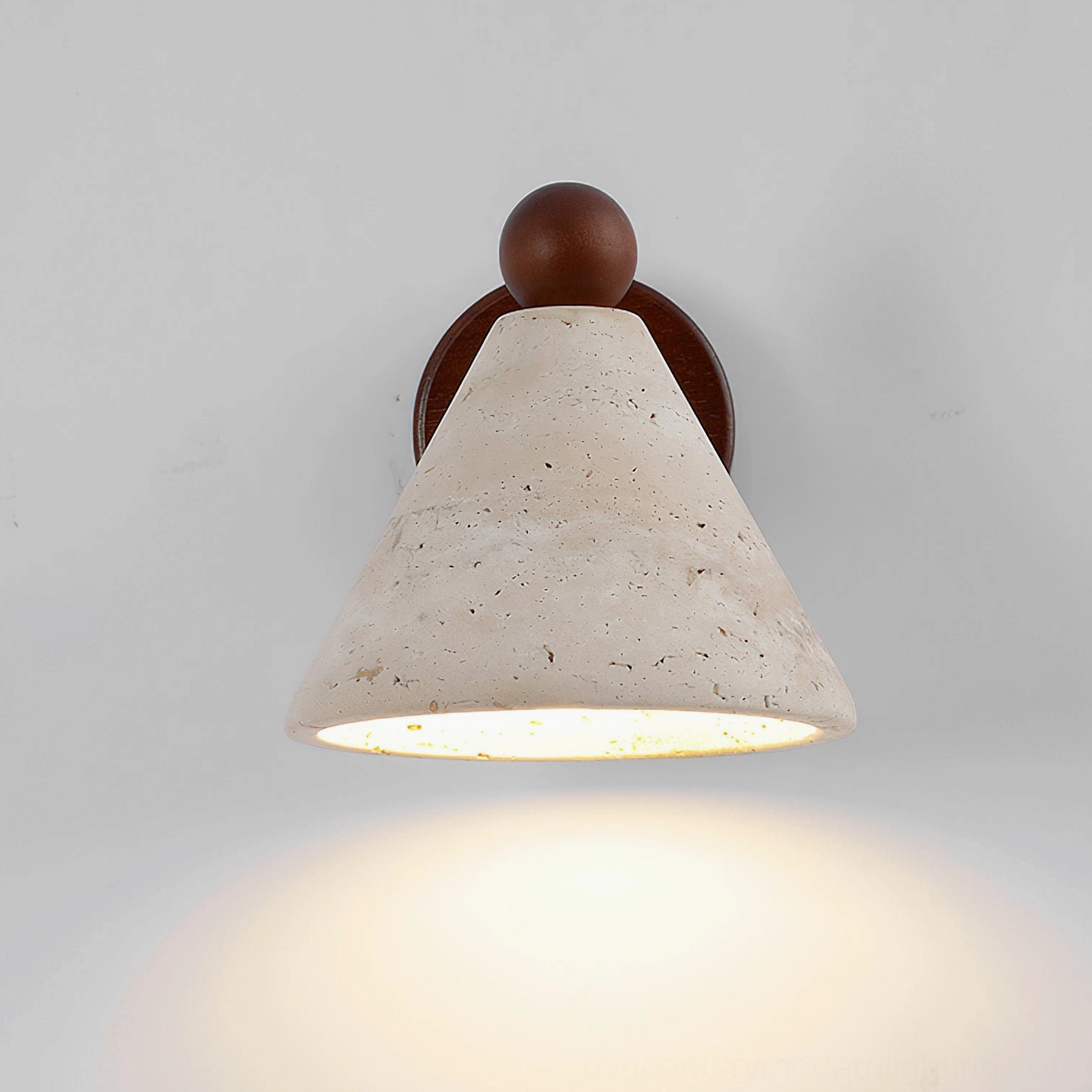Natural travertine limestone wall sconce with warm earthy tones, contemporary minimalist lighting fixture