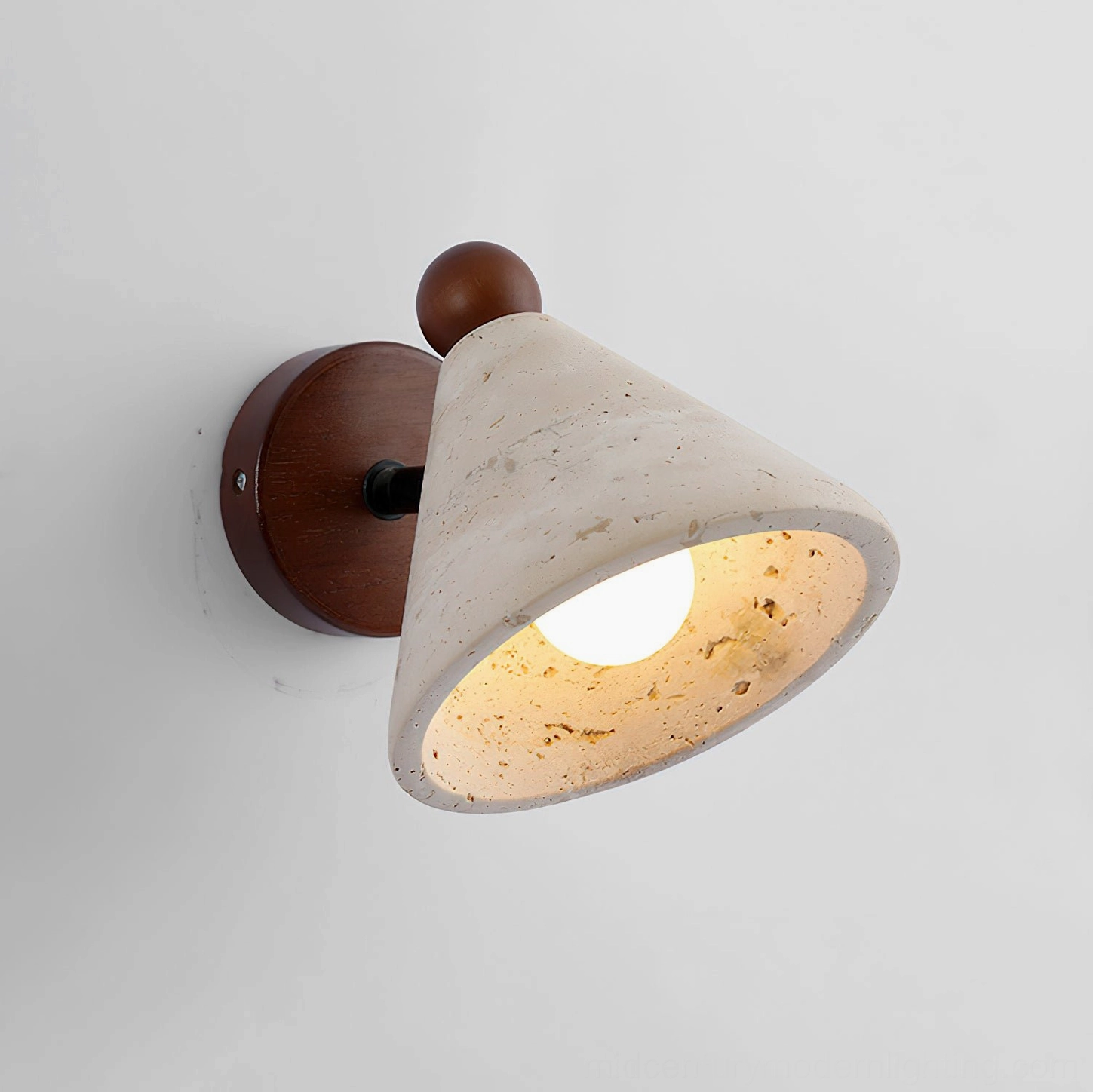Side view of illuminated Tiber travertine wall sconce with visible warm bulb glow through natural stone