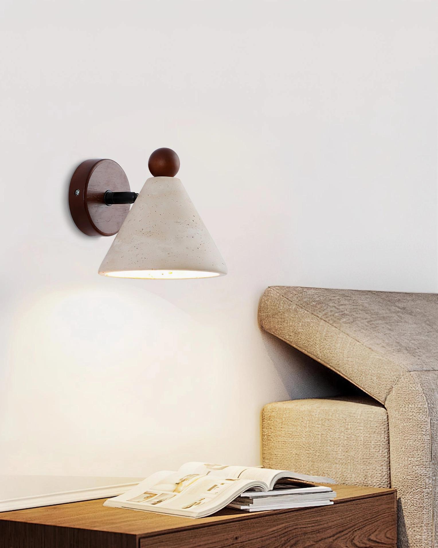 Illuminated travertine wall sconce casting warm ambient light in living room with side table and sofa