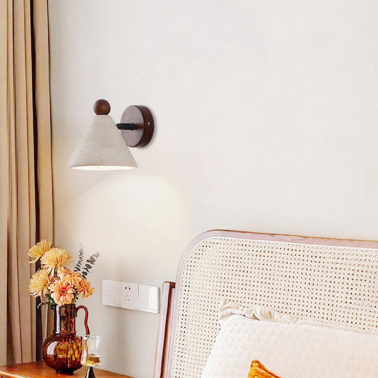 Travertine cone wall light in warm bedroom with rattan headboard, boho-minimalist interior design