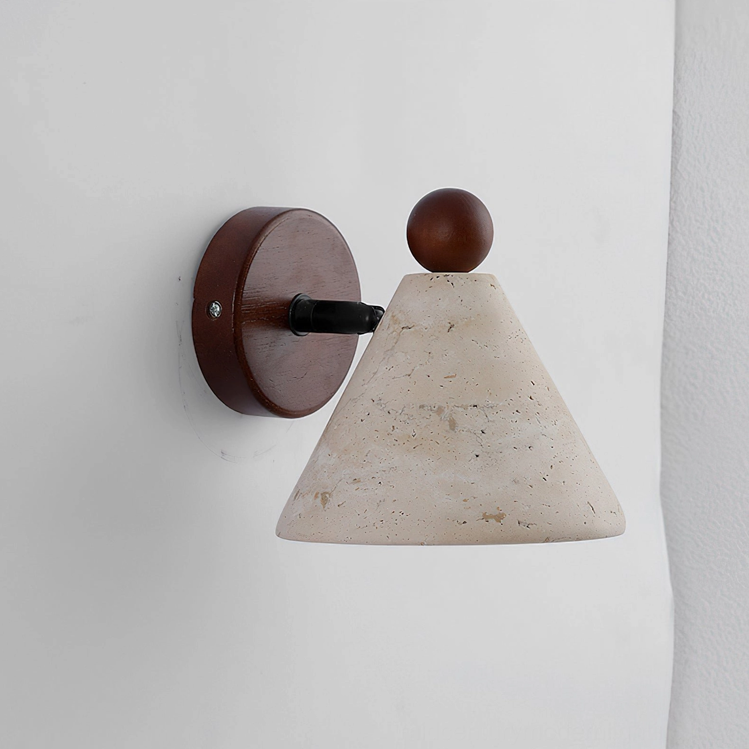 Tiber natural travertine cone wall sconce, minimalist studio view showcasing walnut wood and metal hardware