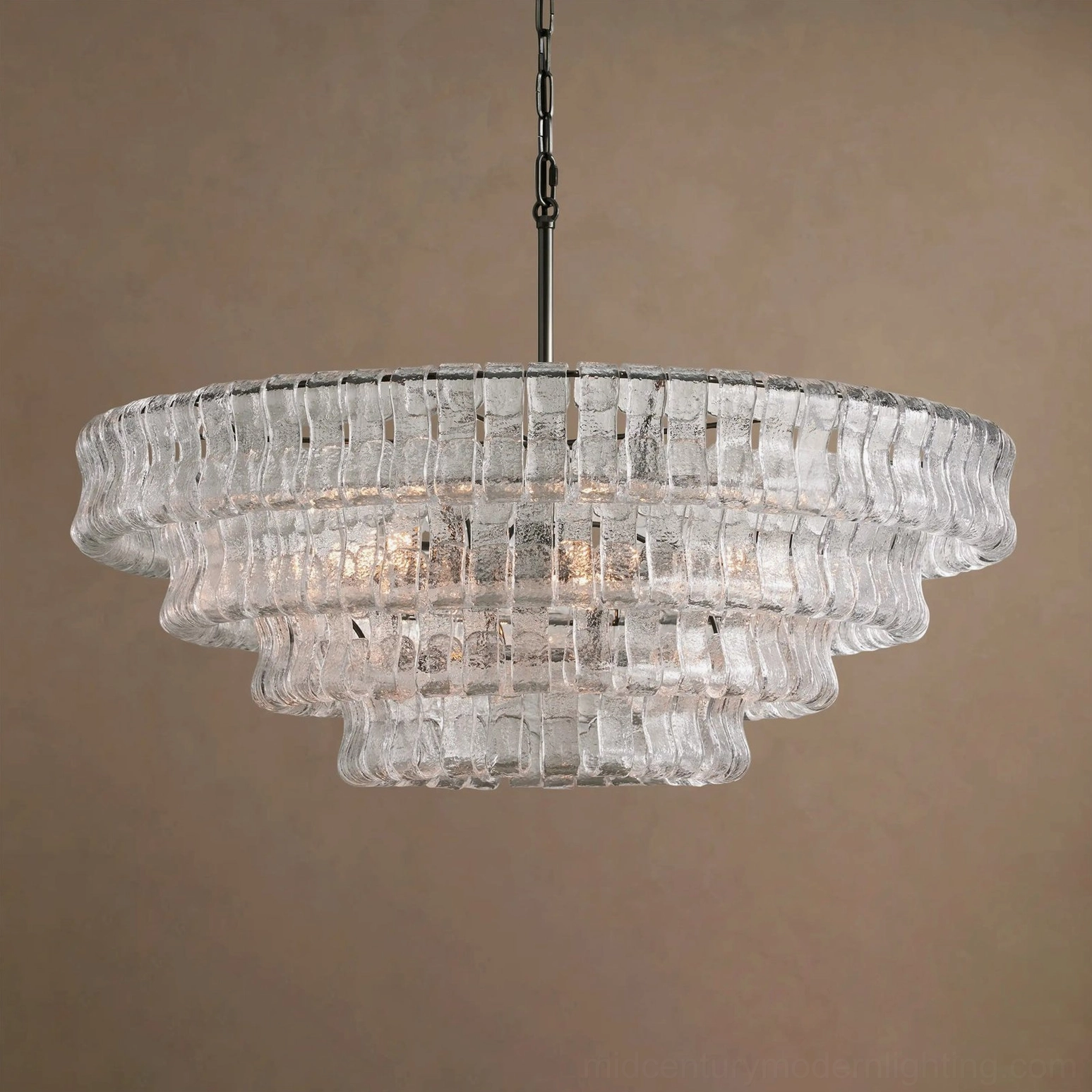 Tiered round chandelier illuminated, multiple glass layers refracting light, creating dynamic luminous effect and shadow patterns