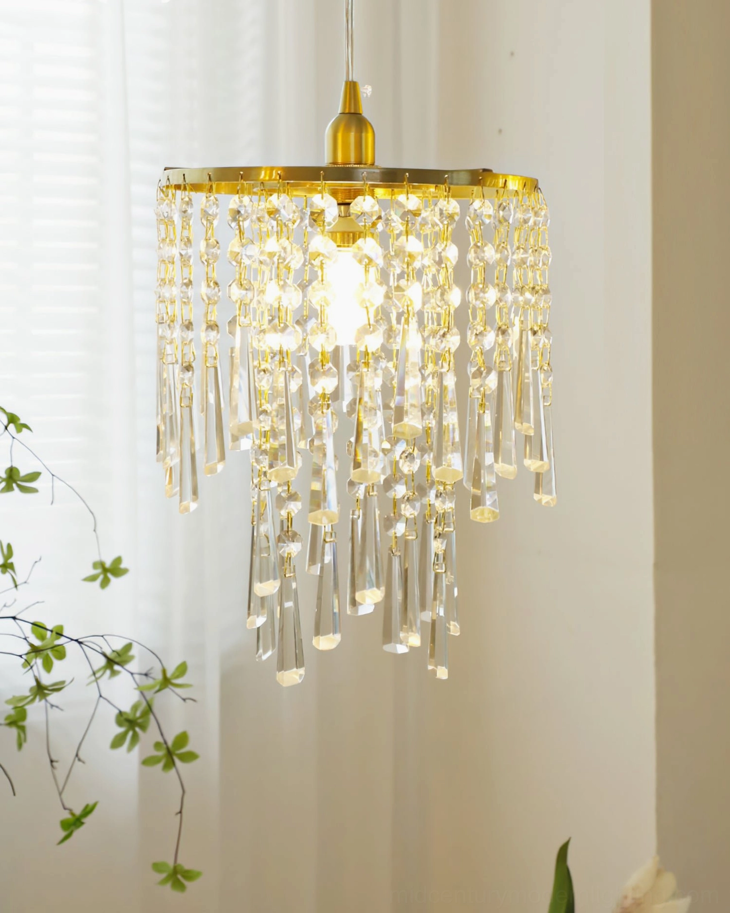 Tiered crystal tassel chandelier with brass gold hardware and exposed warm light bulb, illuminated interior showcase