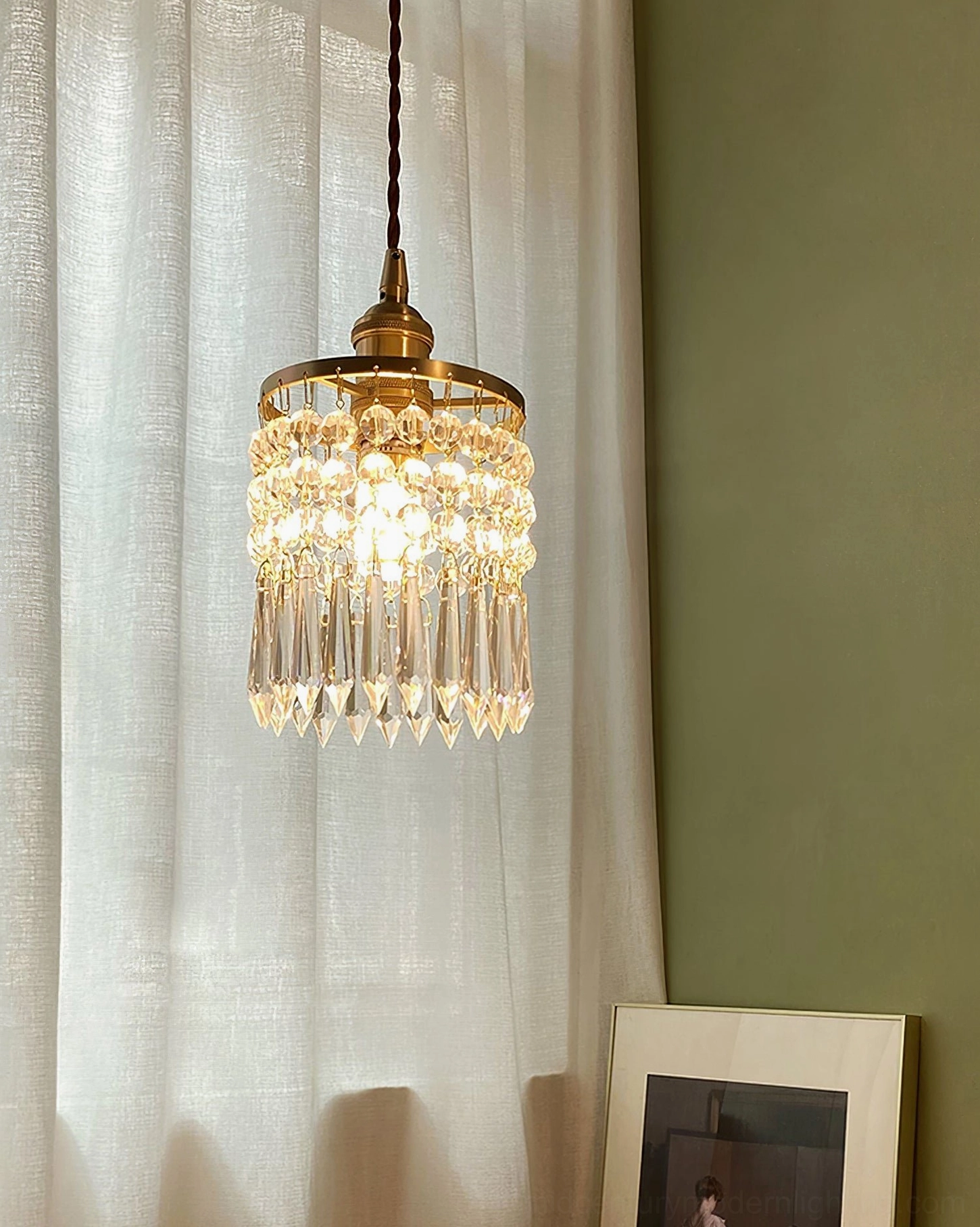Tiered crystal pendant lighting fixture side view with brass gold frame