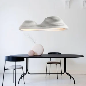 Organic layered pendant lamp suspended over minimalist dining table in modern home with warm neutral decor
