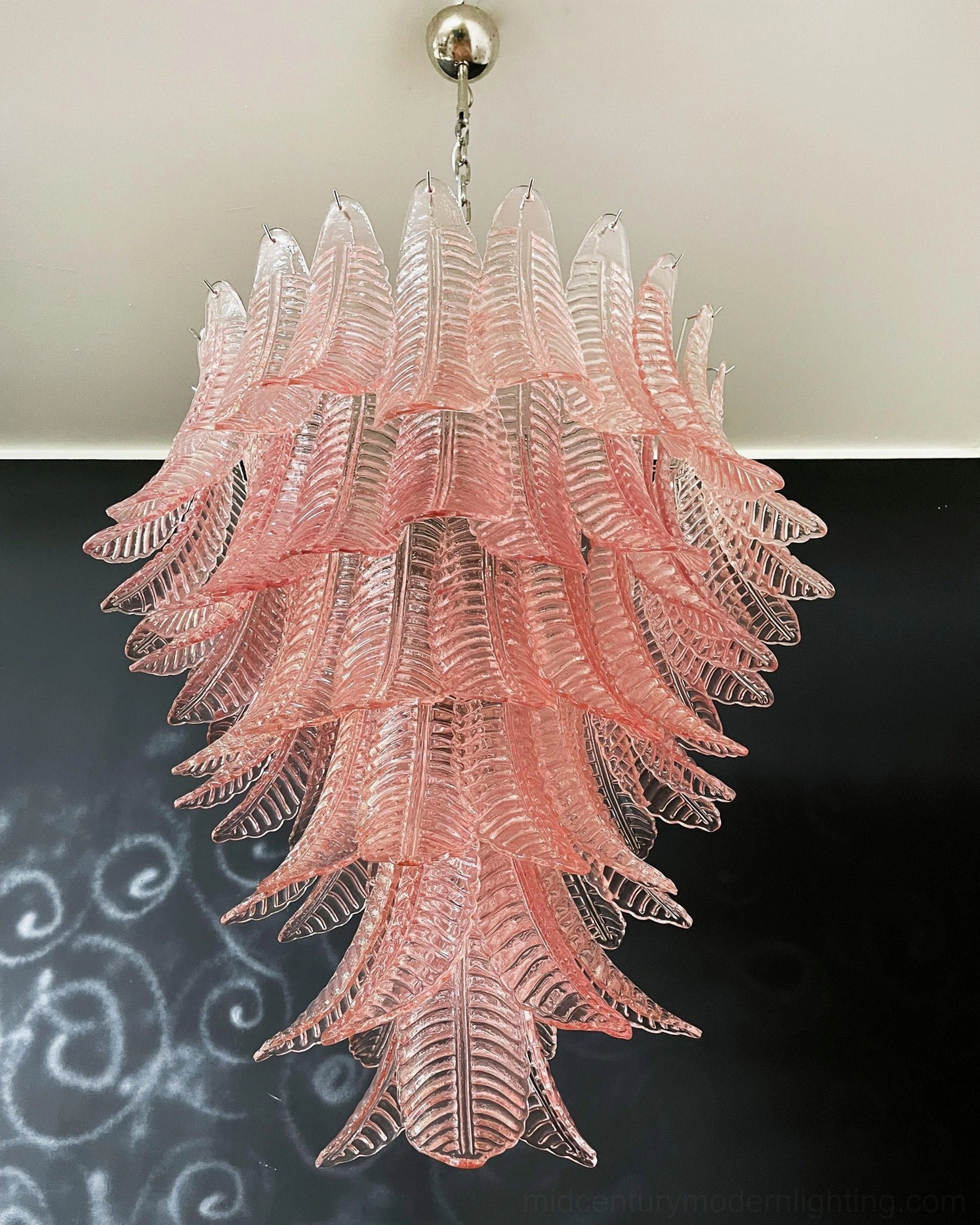 Tiered cascading pink glass Murano chandelier frontal view on dark wall