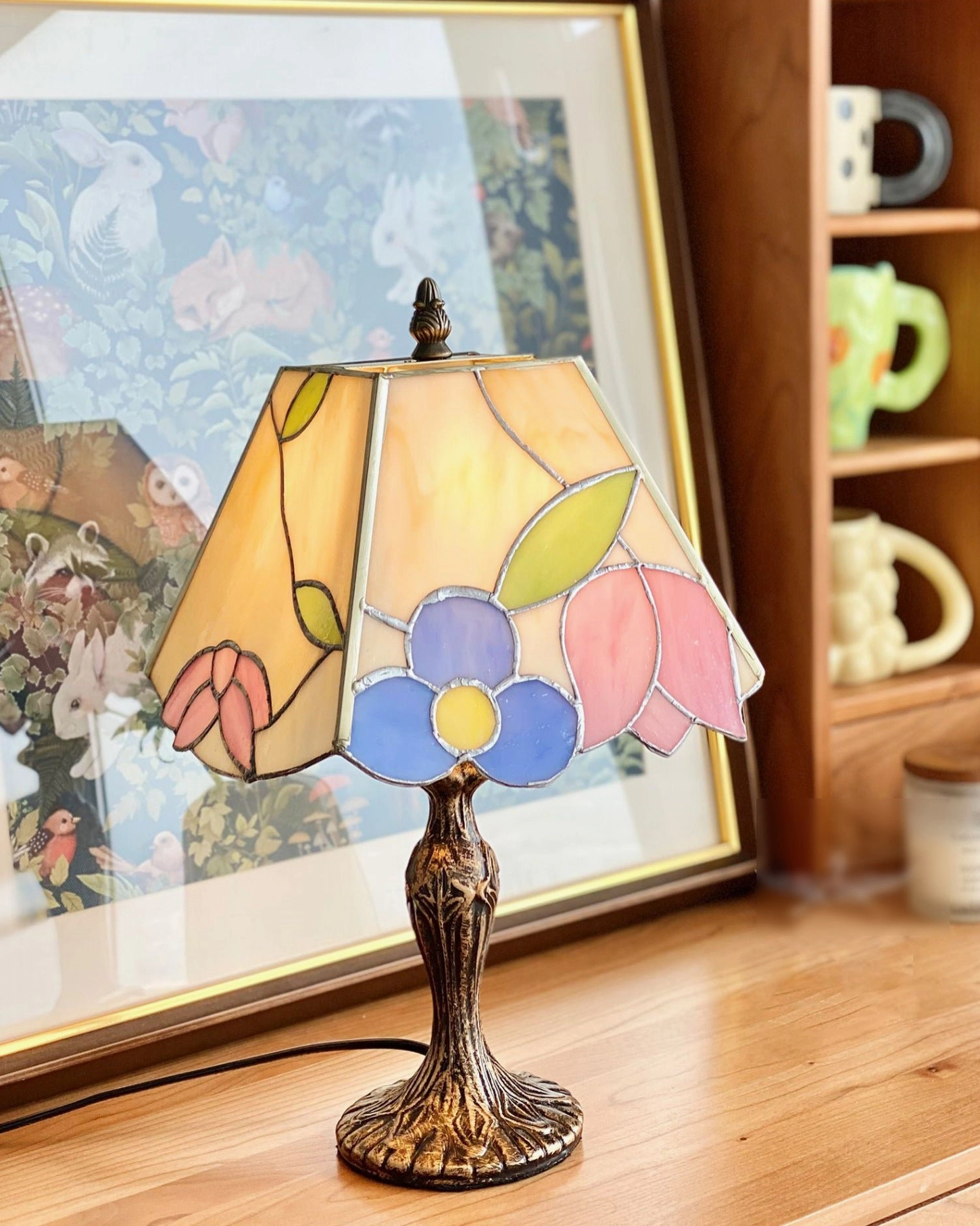 Tiffany stained glass table lamp on home office desk with wall art and ceramic decor