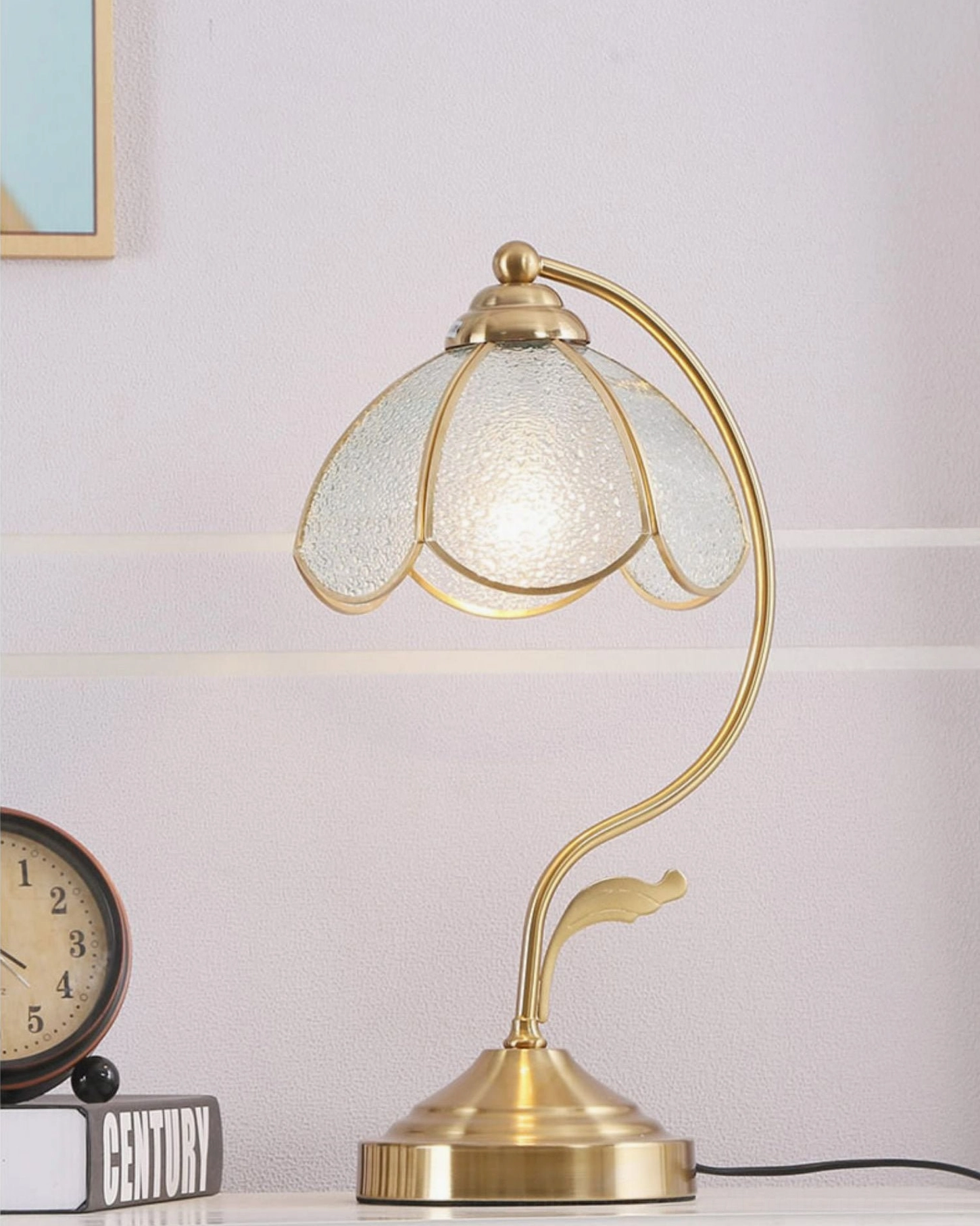 Illuminated Tiffany table lamp glowing with warm light, frosted glass shade on tabletop with books