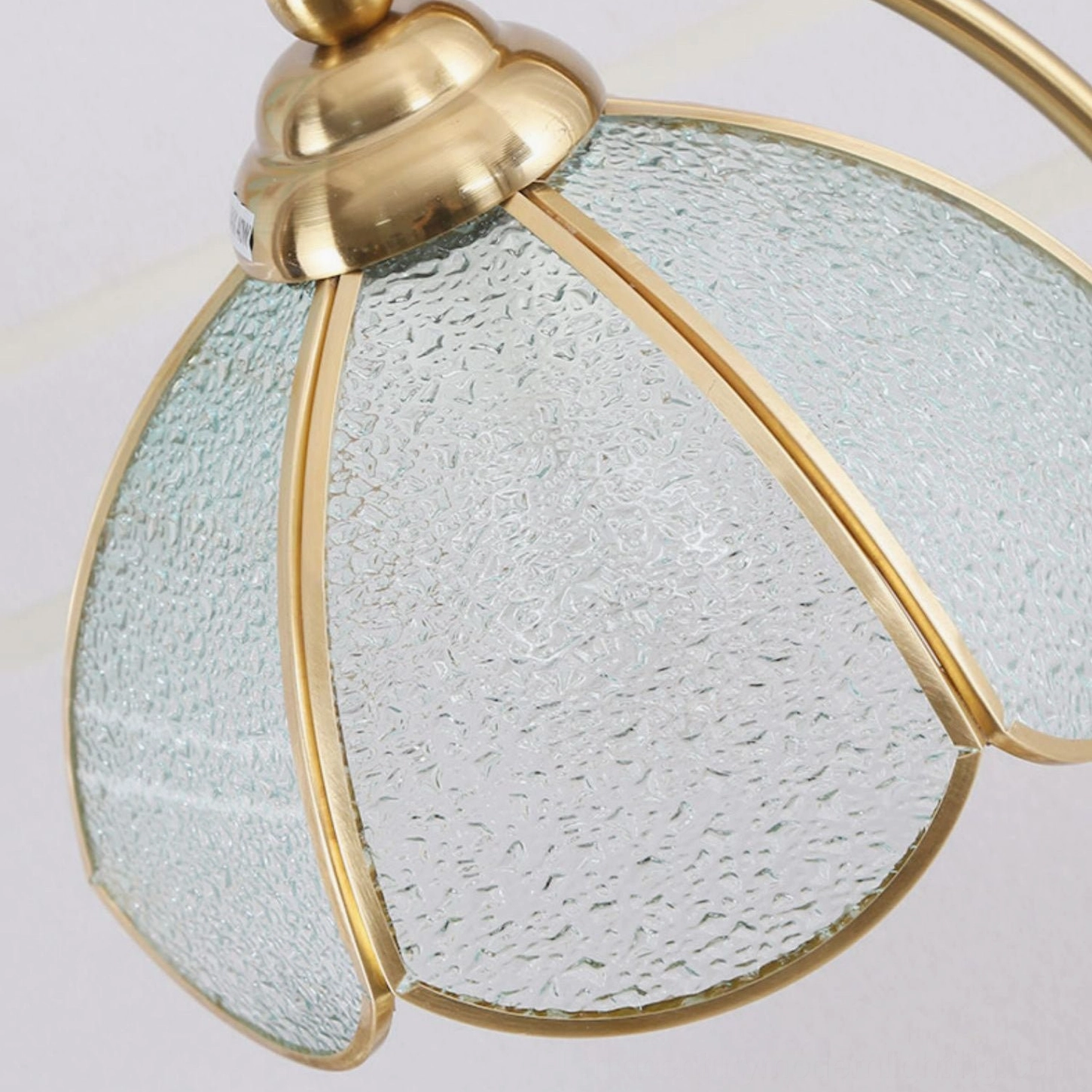 Close-up side angle of mixed blue and clear stained glass Tiffany lamp shade with brass gold frame