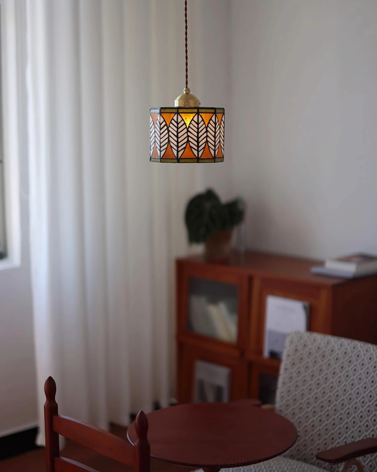 Compact stained glass leaf pendant fixture with brass hardware in home lounge setting