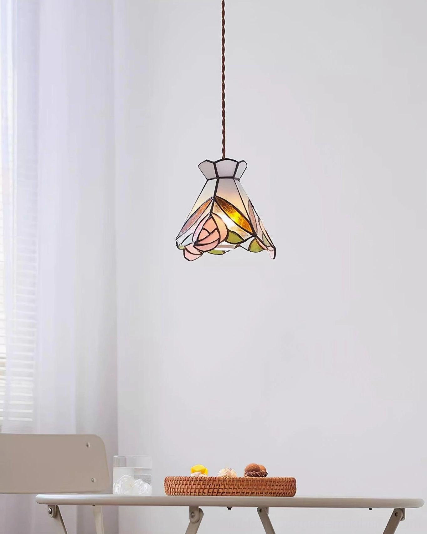 Tiffany rose stained glass pendant hanging above dining area with natural window light