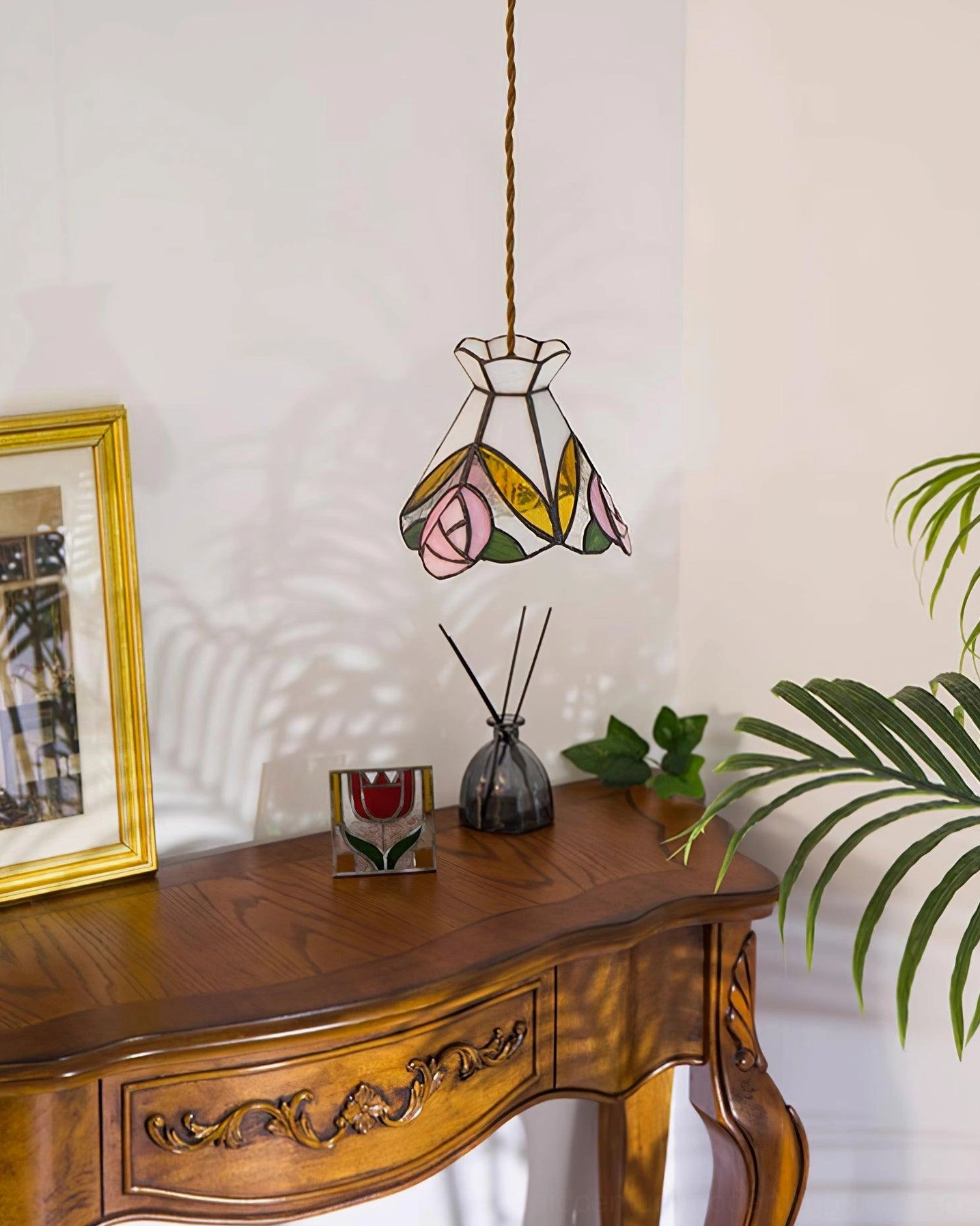 Tiffany pendant with pink, white, and yellow floral glass design hanging in interior setting