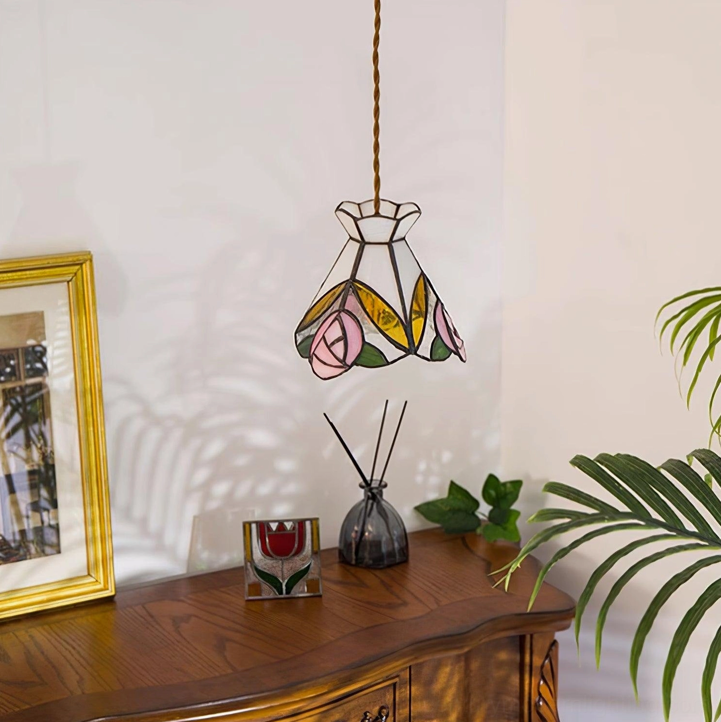 Tiffany rose stained glass pendant hanging in vintage home with wooden table - three-quarter perspective