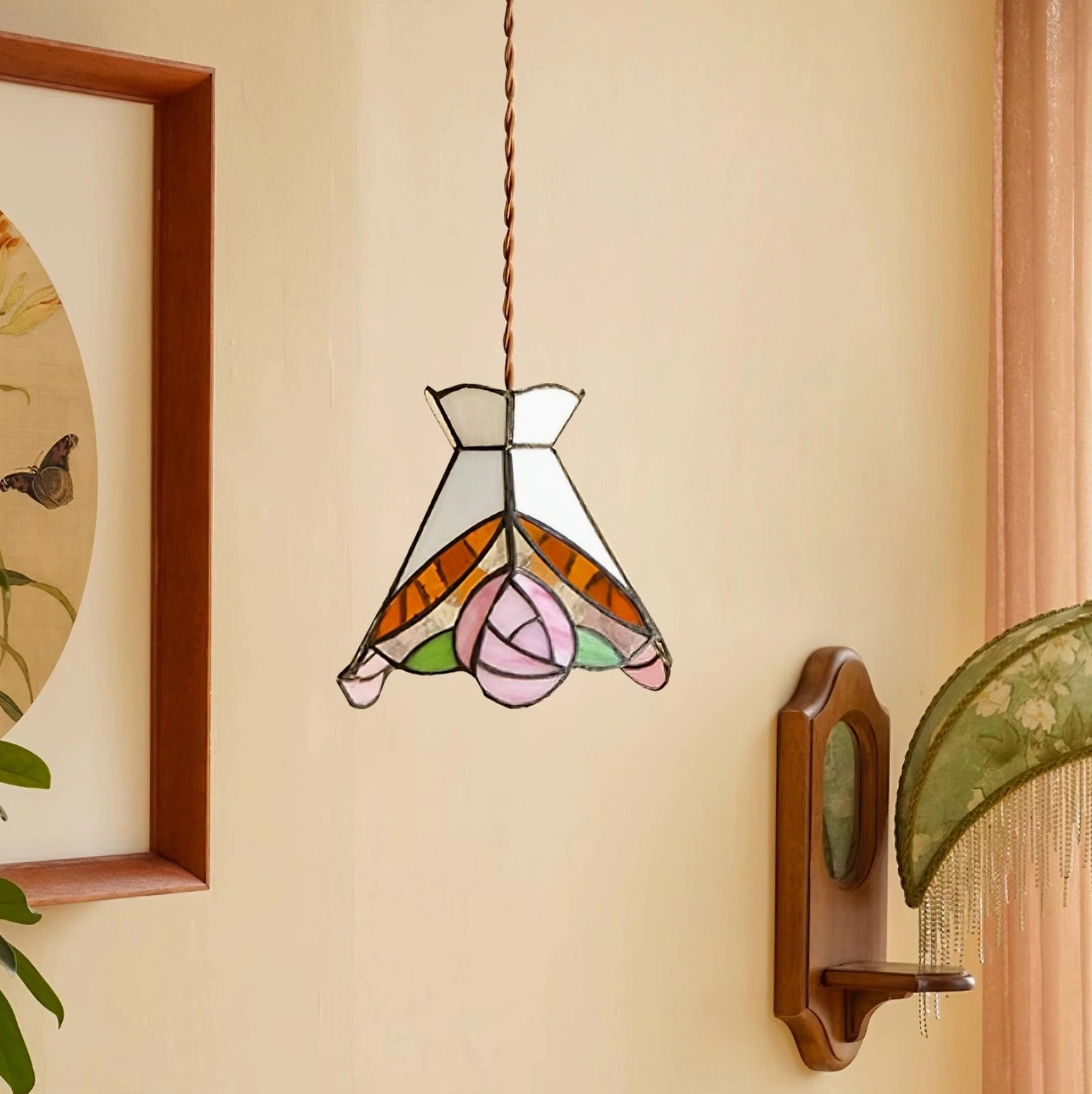Rose-patterned Tiffany stained glass pendant hanging in vintage hallway with wall artwork and orange accents