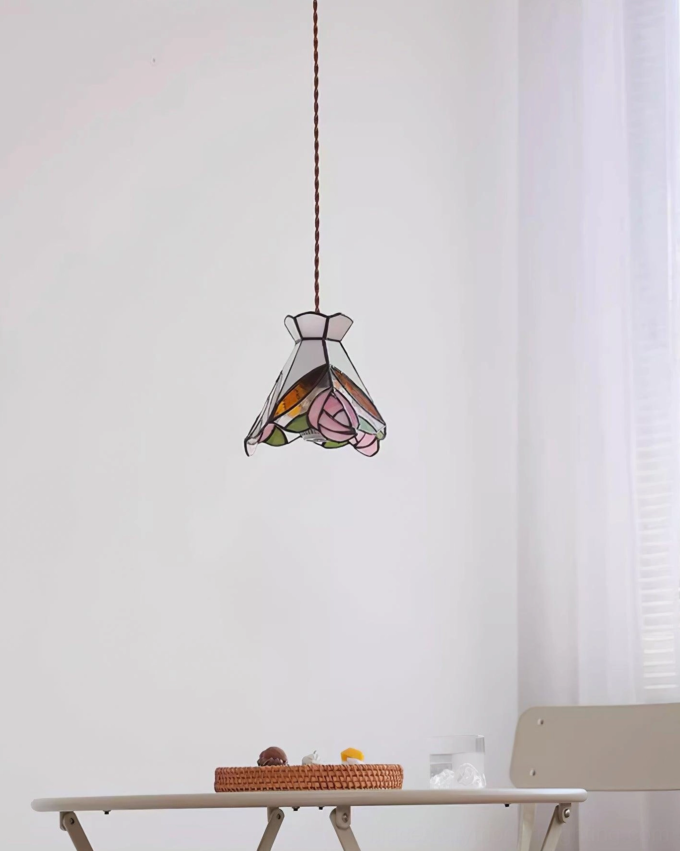 Tiffany pendant lamp with rose stained glass pattern creating warm ambient lighting in home workspace