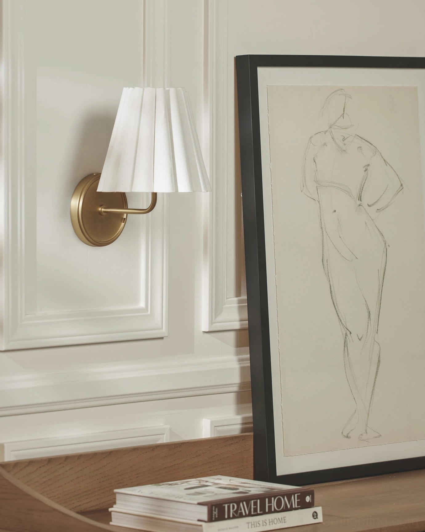 Brass Tilia sconce in formal entryway with framed artwork and elegant minimalist decor styling