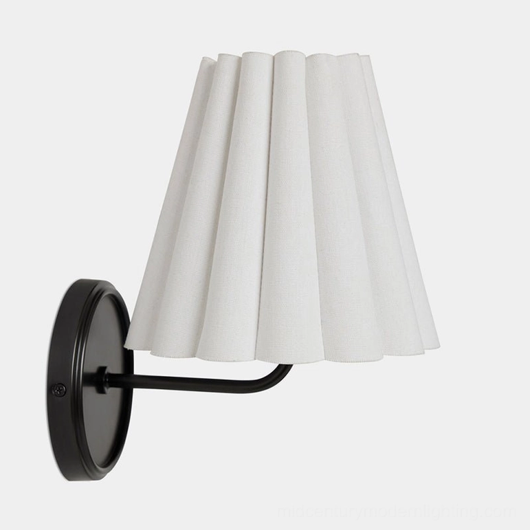 Tilia black metal wall sconce front studio view showing curved arm and pleated fabric shade detail