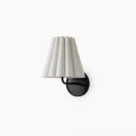 Tilia brass and fabric wall sconce with pleated white shade on studio background, mid-century modern design