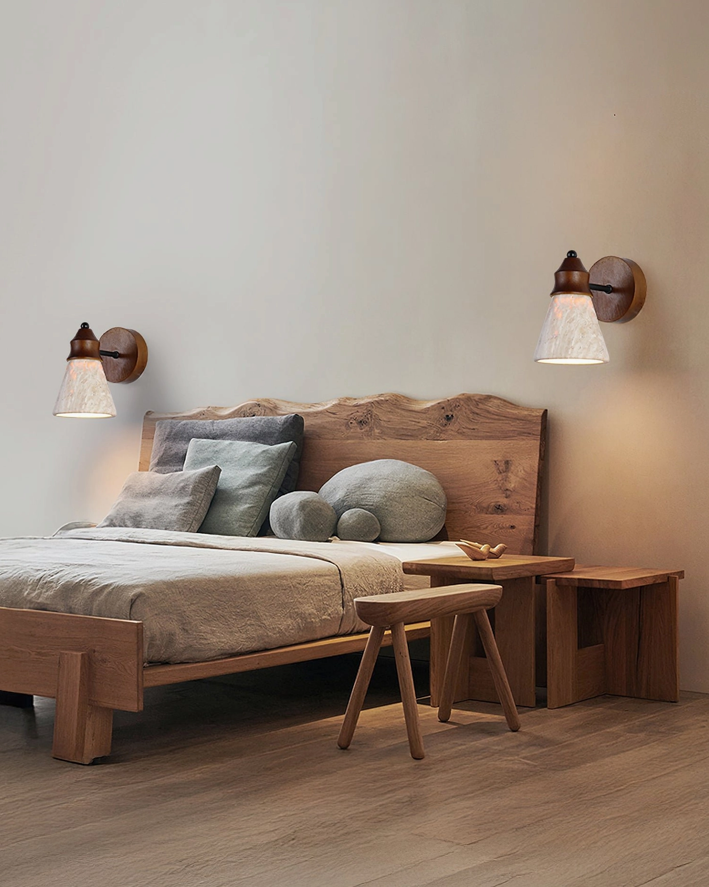 Pair of travertine wall sconces flanking wooden bed in farmhouse master bedroom, dual bedside lighting arrangement