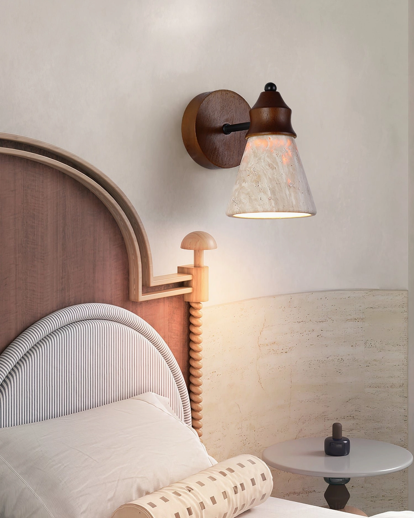 Natural travertine wall sconce in mid-century bedroom with upholstered headboard, warm glow ambient lighting