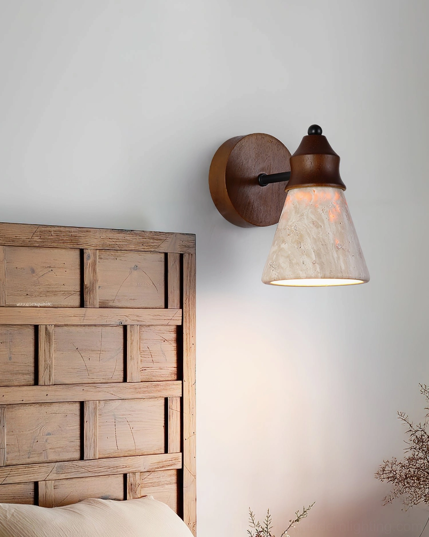 Toltec travertine sconce mounted beside reclaimed wood headboard, side view of rustic modern bedroom lighting