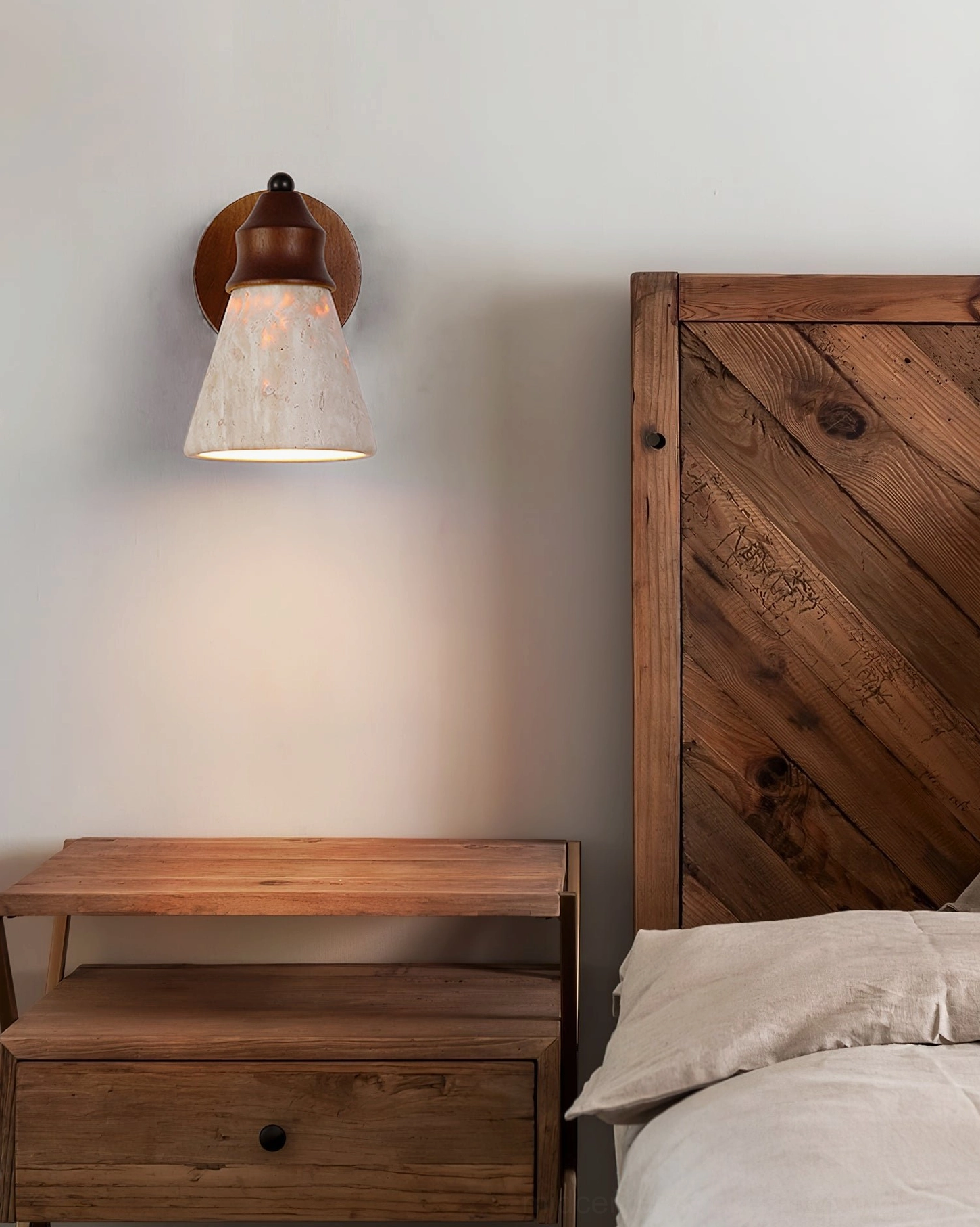 Mid-century travertine wall light in contemporary bedroom with wooden headboard, close-up detail of natural stone texture