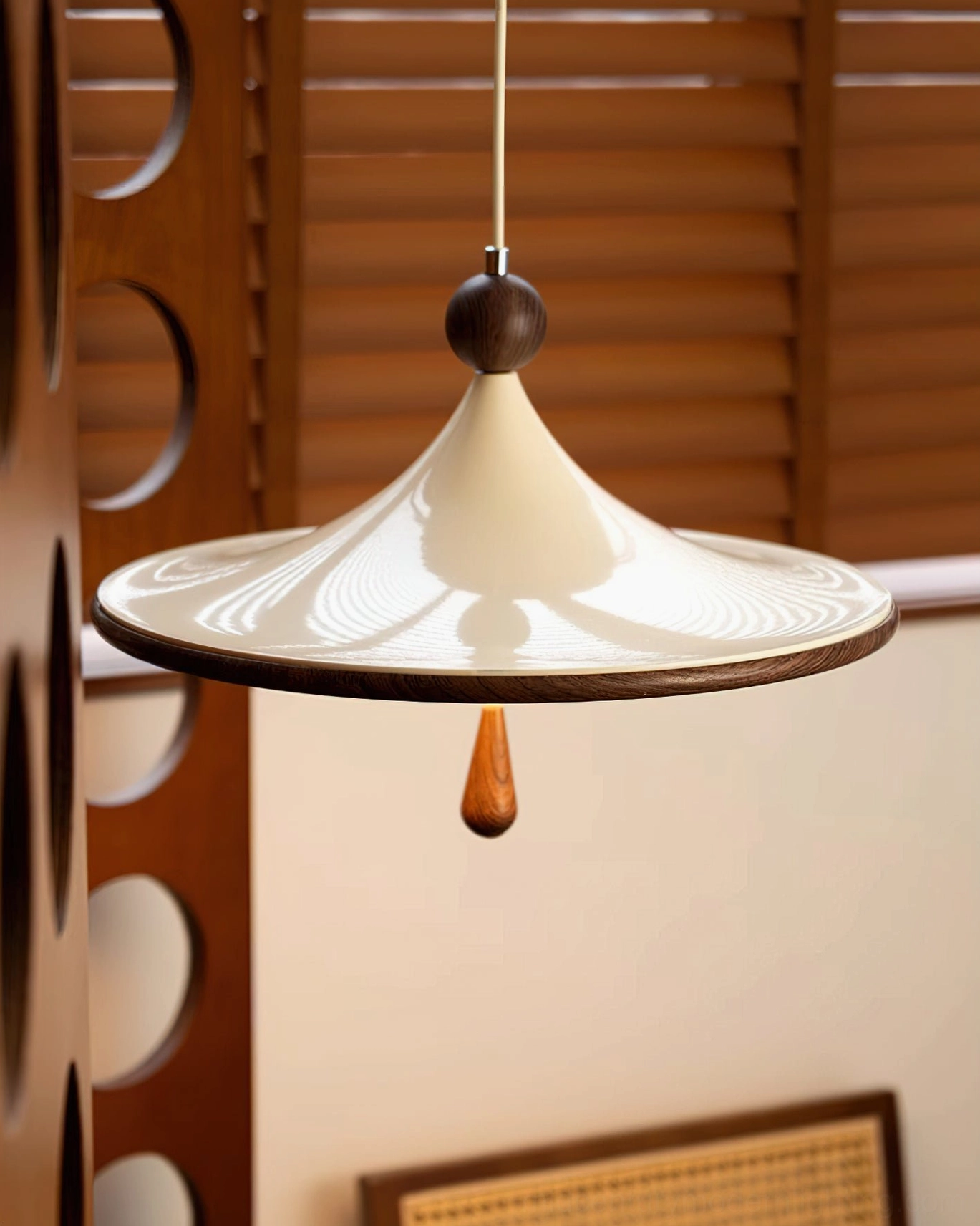 Close-up detail of Tomaso pendant light shade curve and dark wood spherical finial accent