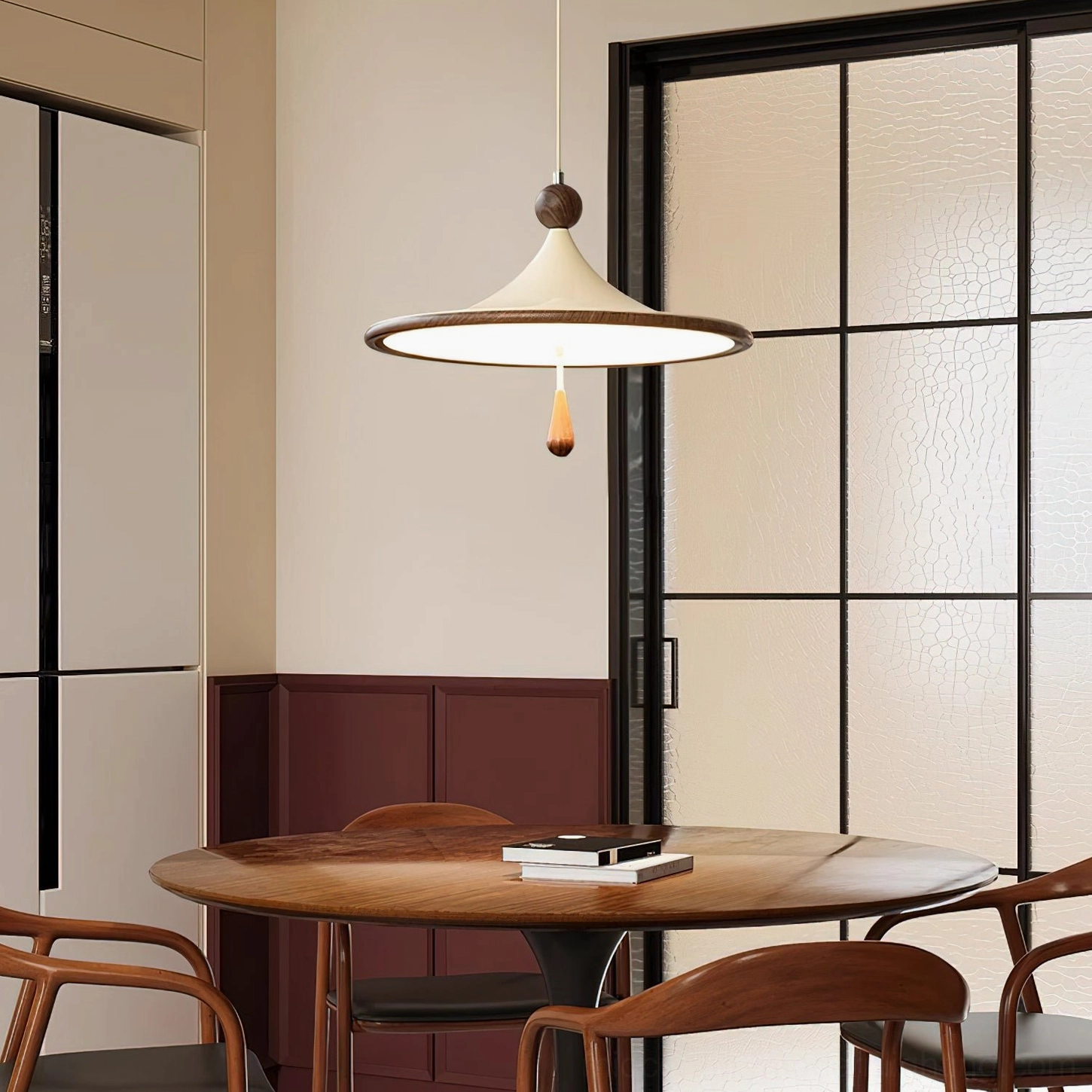 Tomaso pendant light suspended above modern dining table with dark wood furniture and frosted glass partition