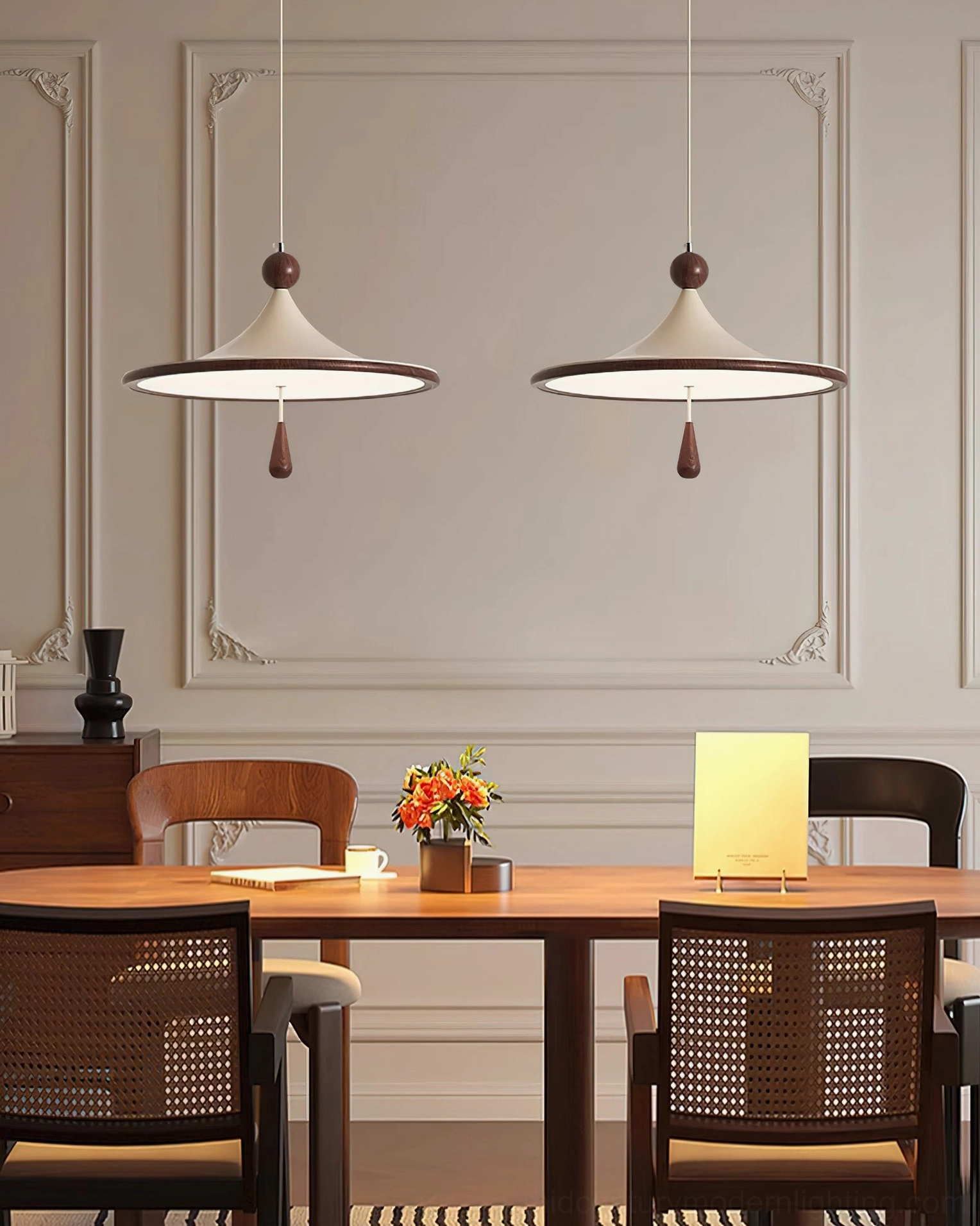 Two matching Tomaso pendant lights suspended in coordinated dining room with wainscot wall details