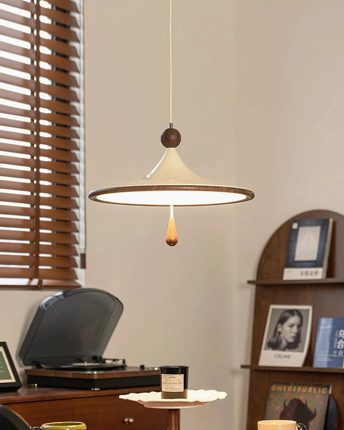 Tomaso pendant lamp beside retro record player showcasing warm light glow and curved shade design