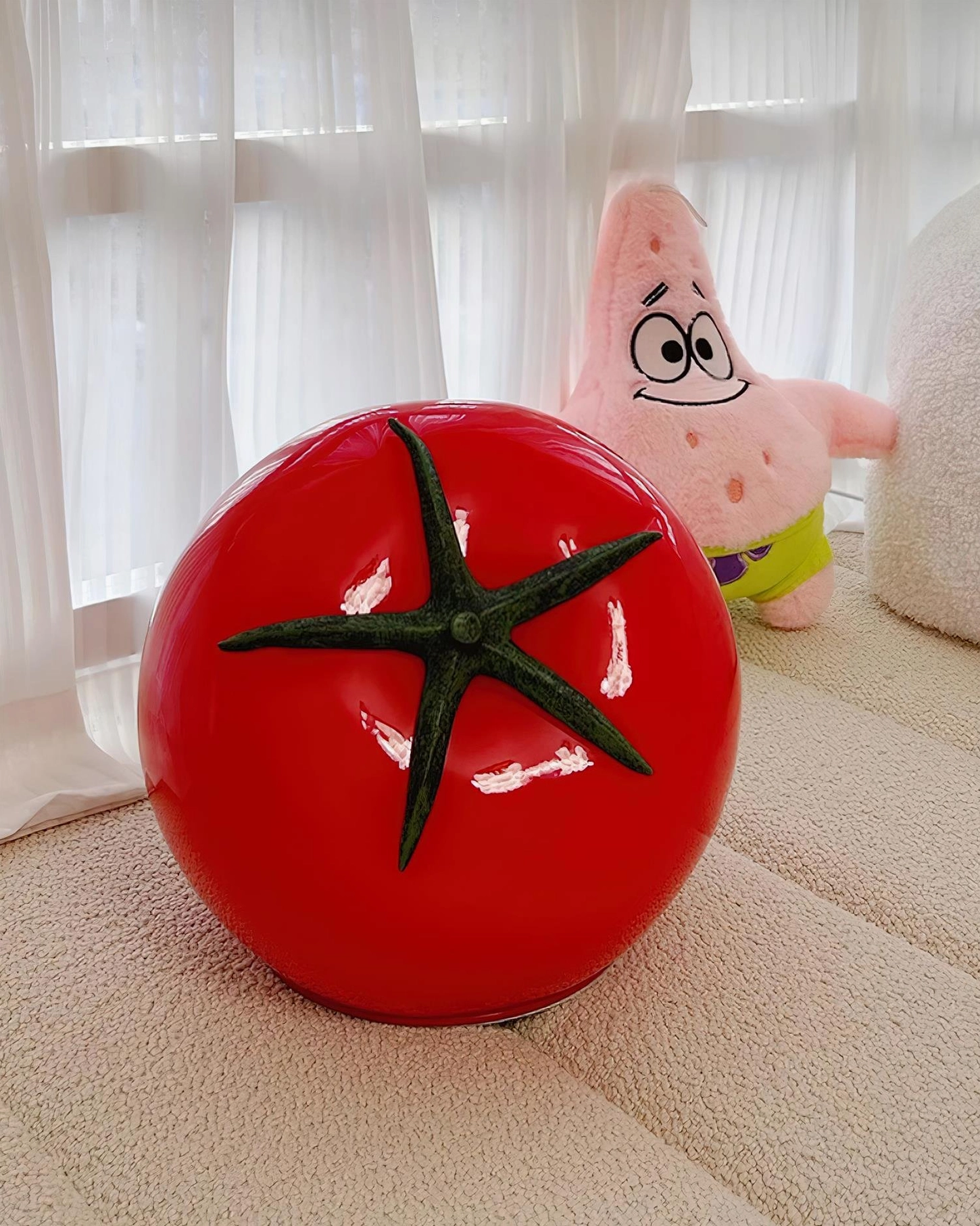 Red tomato glass lamp three-quarter view on soft fabric background, minimalist cute home style