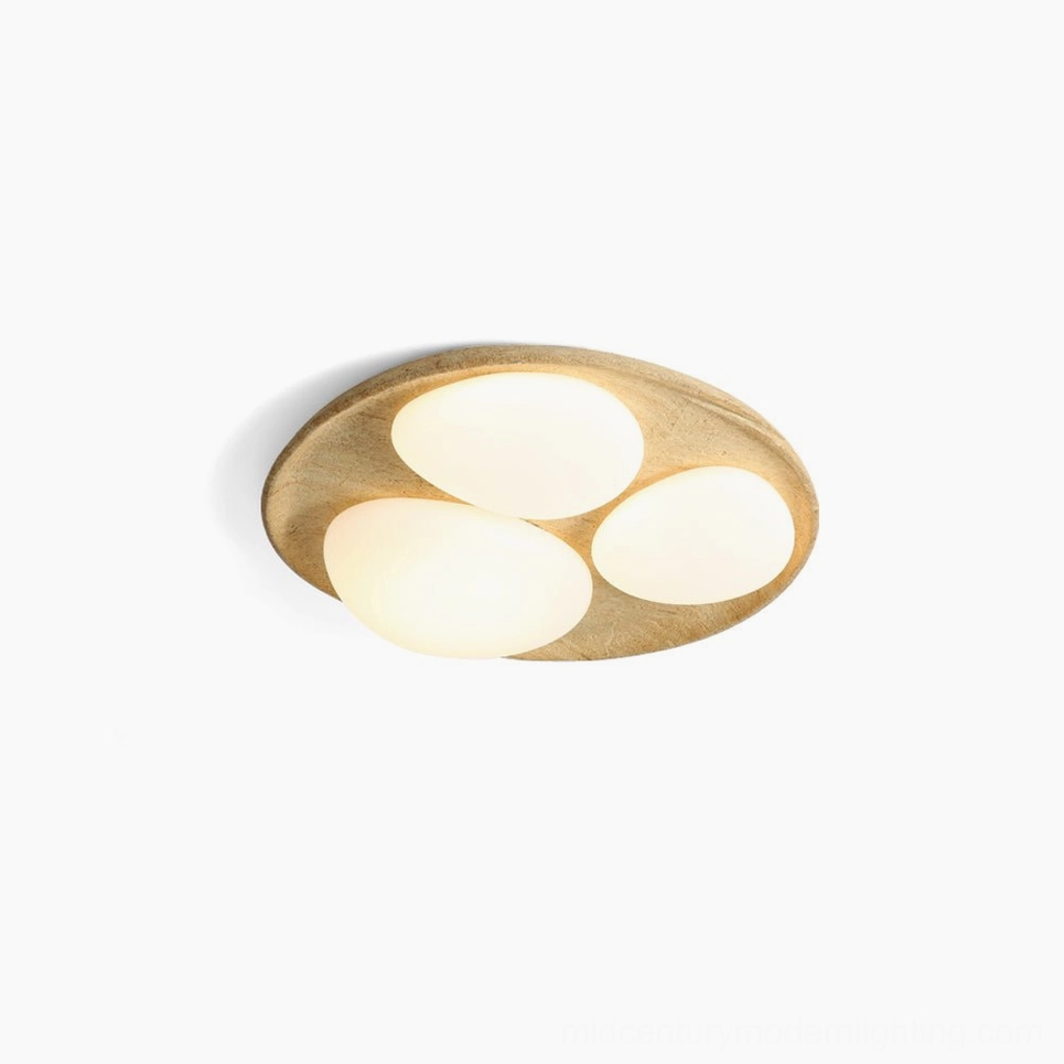 Topo organic ceiling light studio flat lay overhead view showing stone mixture base with three frosted oval acrylic diffusers in warm beige tone