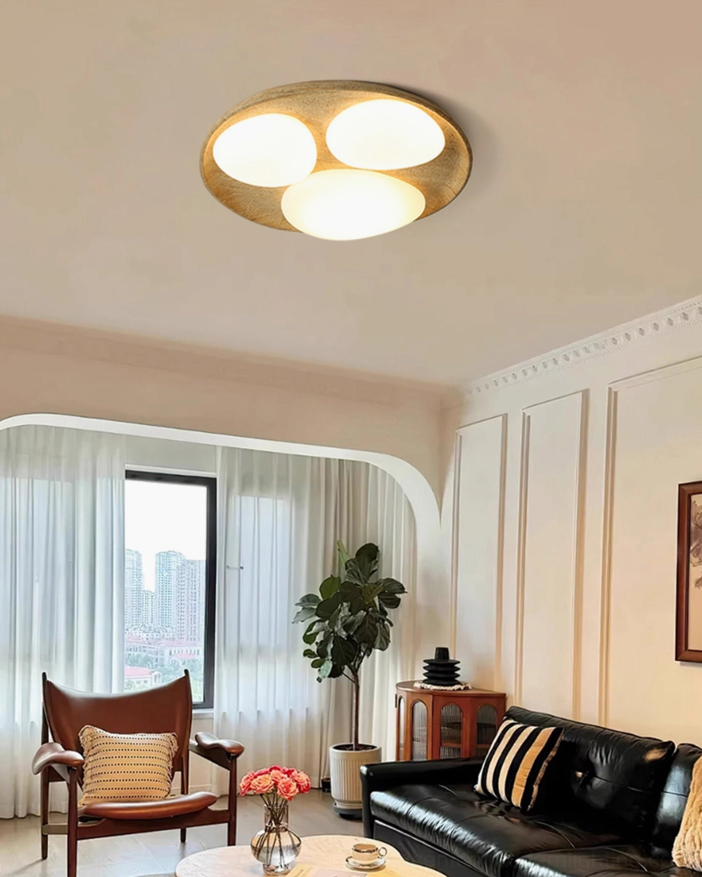 Topo organic stone ceiling light in retro French living room creating warm atmospheric lighting with compact three-lamp design