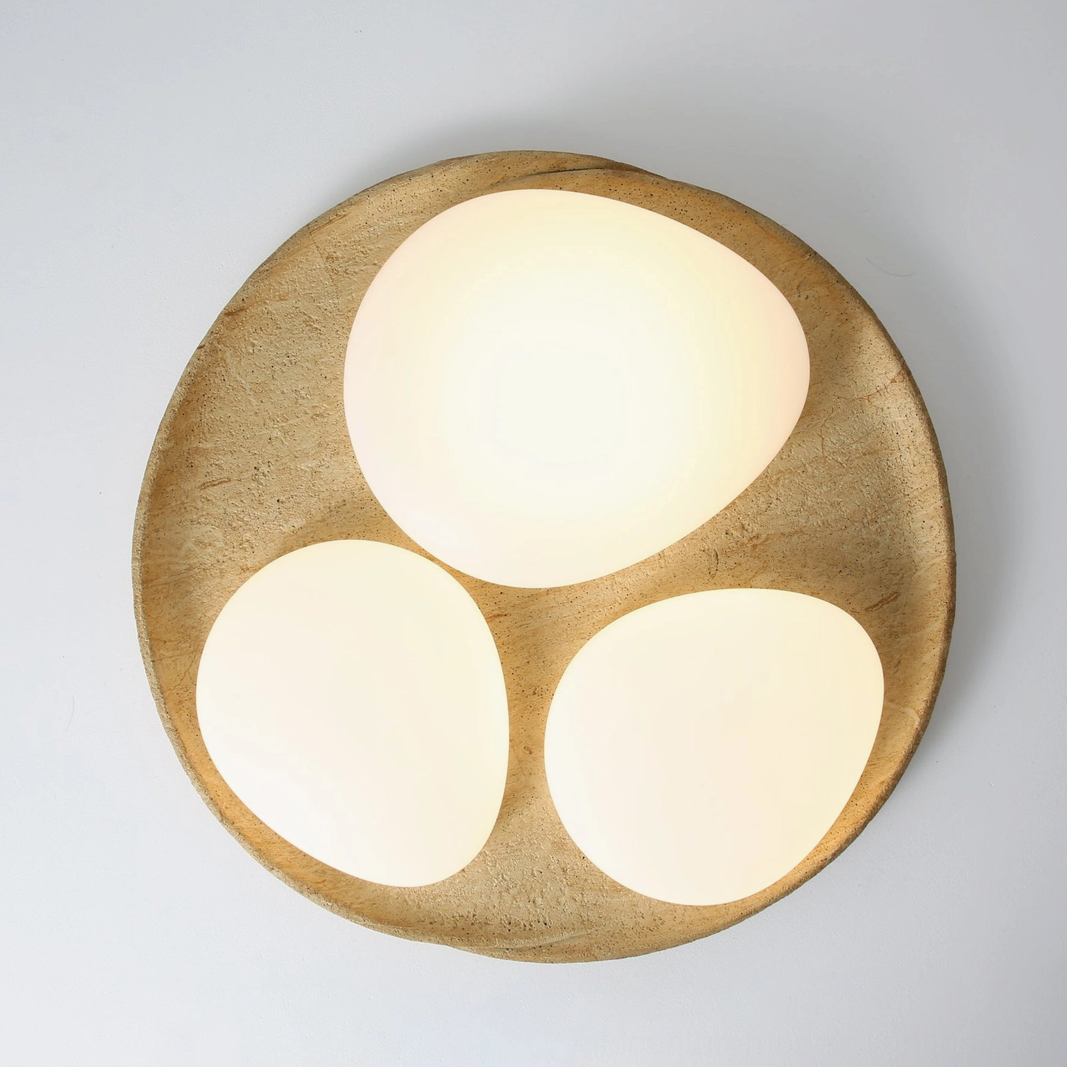 Topo modern organic ceiling light overhead studio flat lay with round wood stone base and three large rounded lamp shades