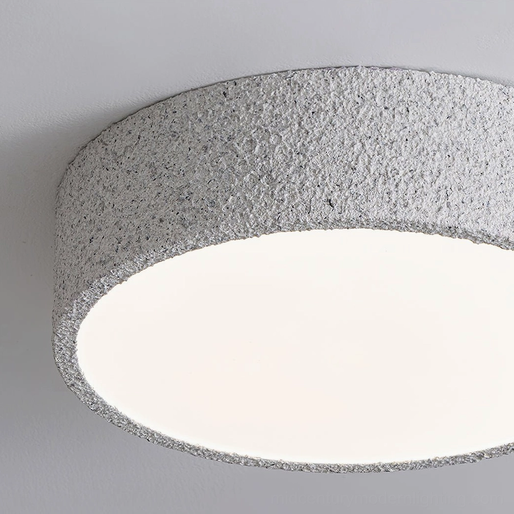 Close-up detail of Toren ceiling light's speckled grey rim and diffused light surface