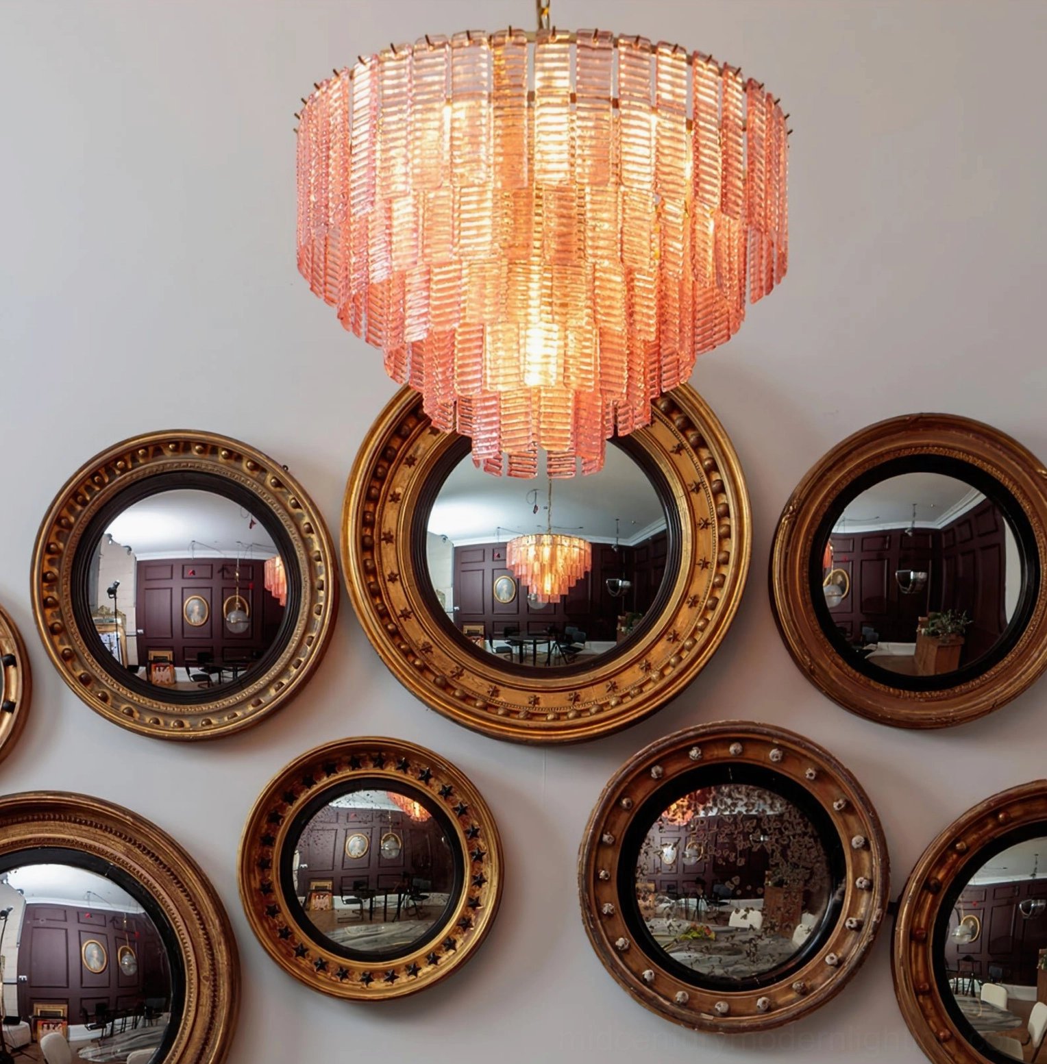 Toronto chandelier glowing above wall-mounted gold mirror creating warm ambient dining atmosphere