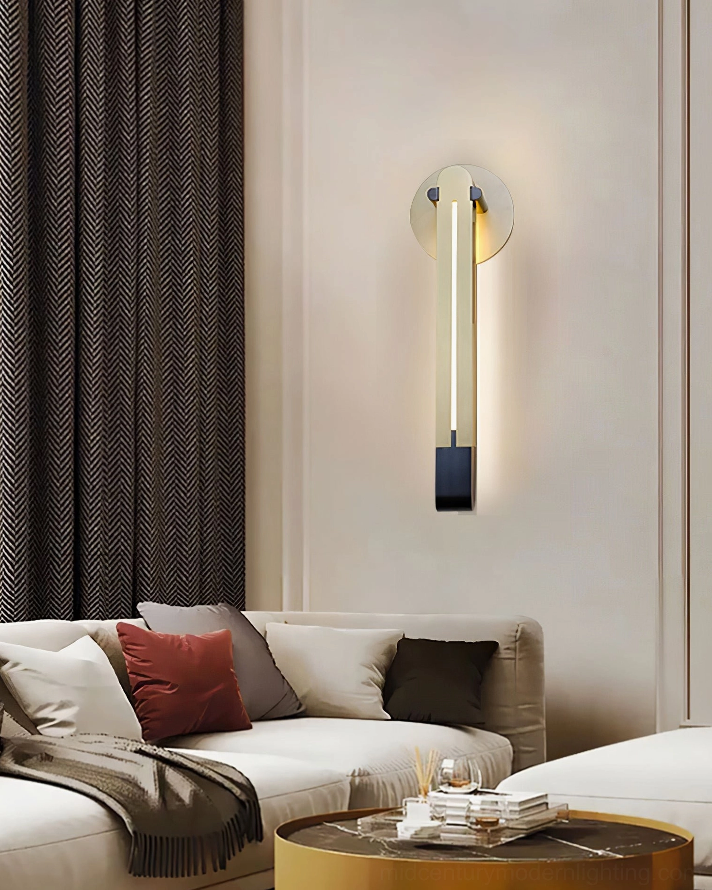 Torpedo wall sconce in brass and black finish emitting warm light in contemporary living room with sofa and coffee table
