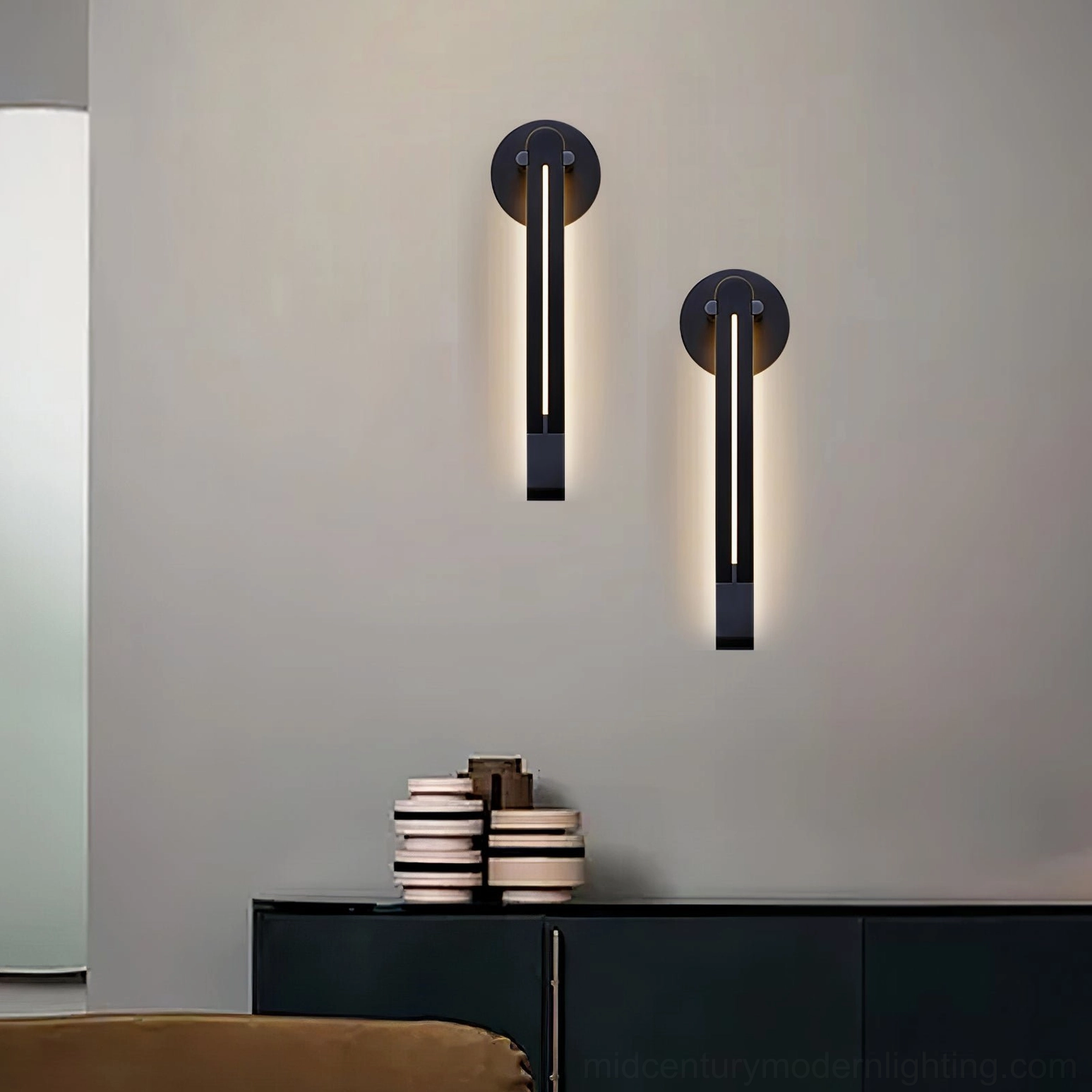 Pair of Torpedo wall sconces installed in modern dark entryway with black storage cabinet, creating architectural focal points