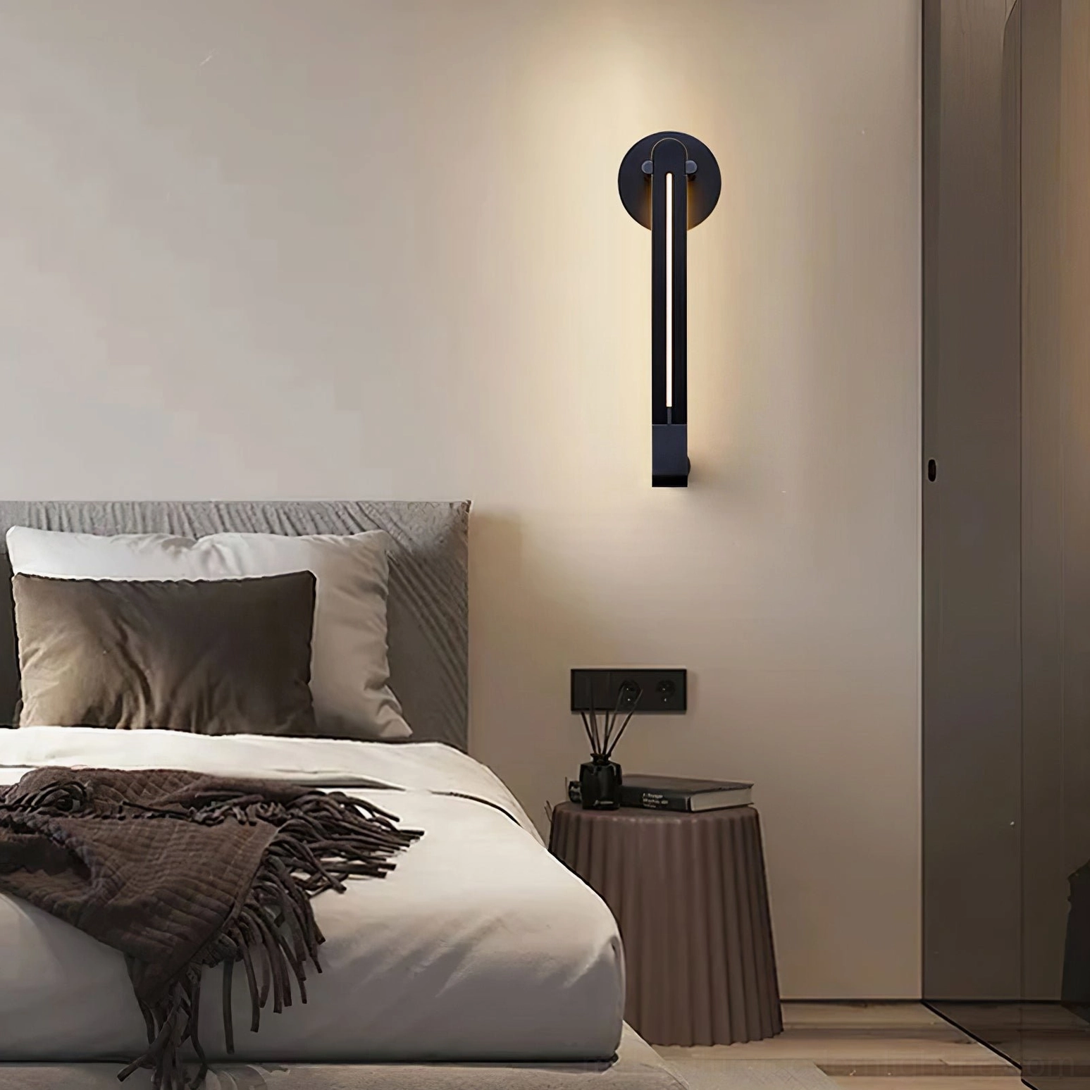 Single Torpedo wall sconce in black mounted as bedroom accent lighting beside bed with nightstand in contemporary bedroom