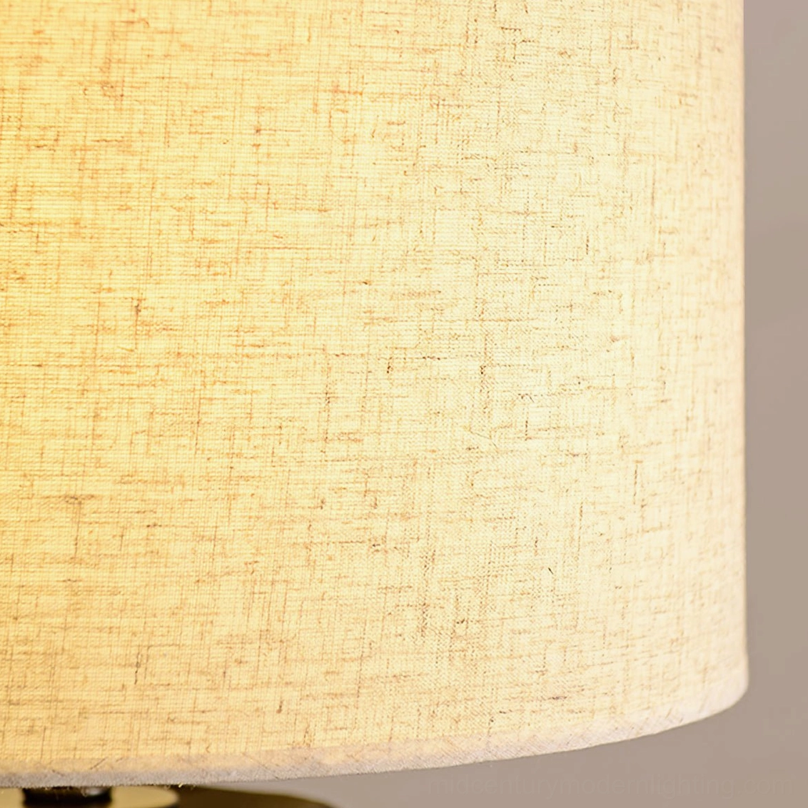 Torso ceramic table lamp showing beige fabric shade warm ambiance